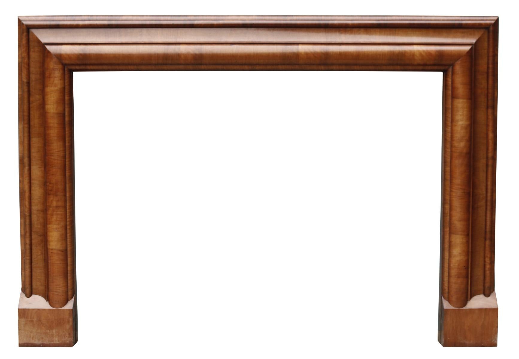An original Art Deco style fire surround of bolection form, veneered in burr walnut.

Additional dimensions:
Opening height 90.5 cm

Opening width 121 cm

Width between outsides of the foot blocks 157.5 cm.