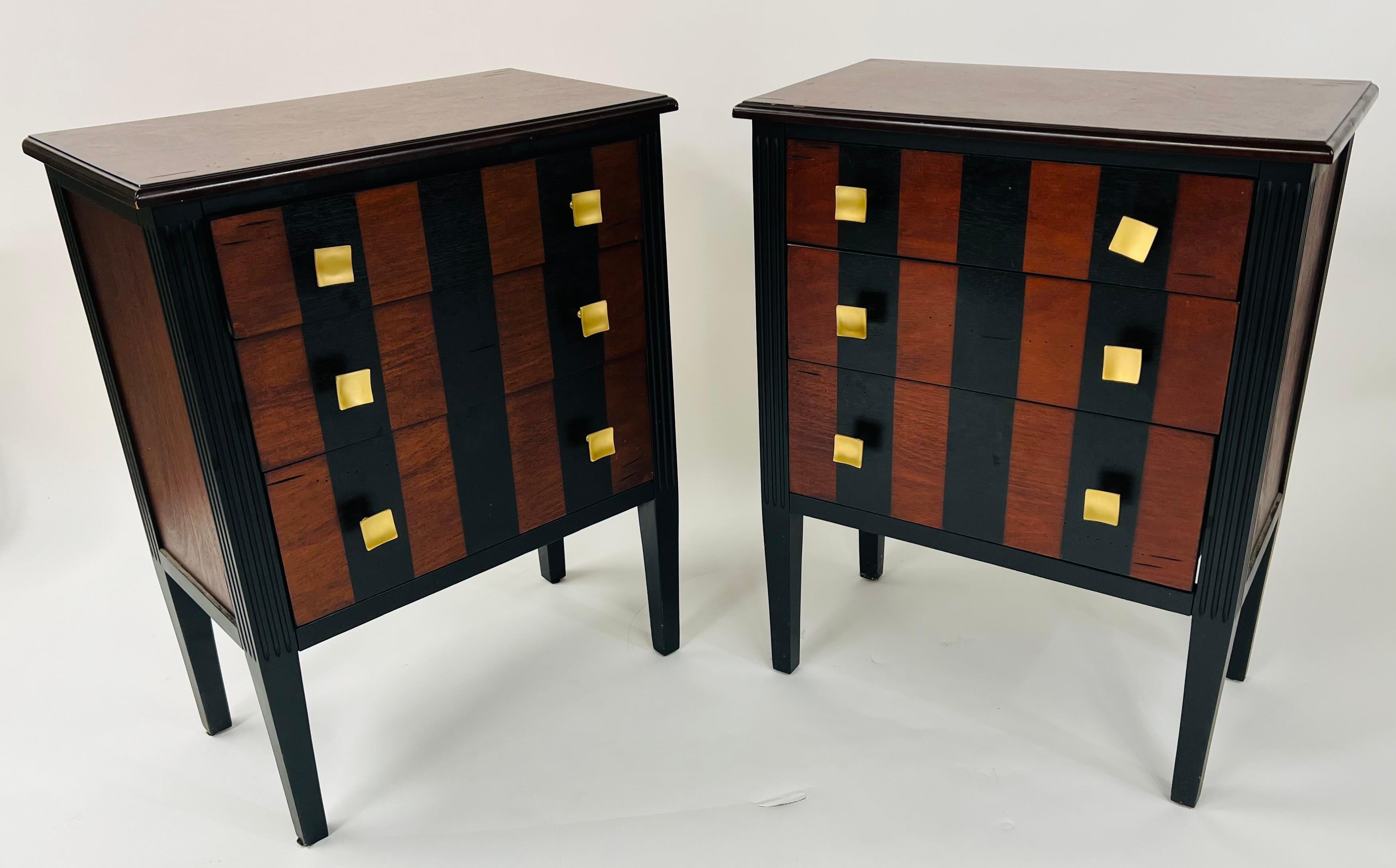 An elegant pair of Art Deco style nightstands, end or side tables made of Rosewood. The pair of nightstands are decorated with strip patterns painted in black and square brass pulls reminiscent of the Art Deco design and shapes. The rosewood natural