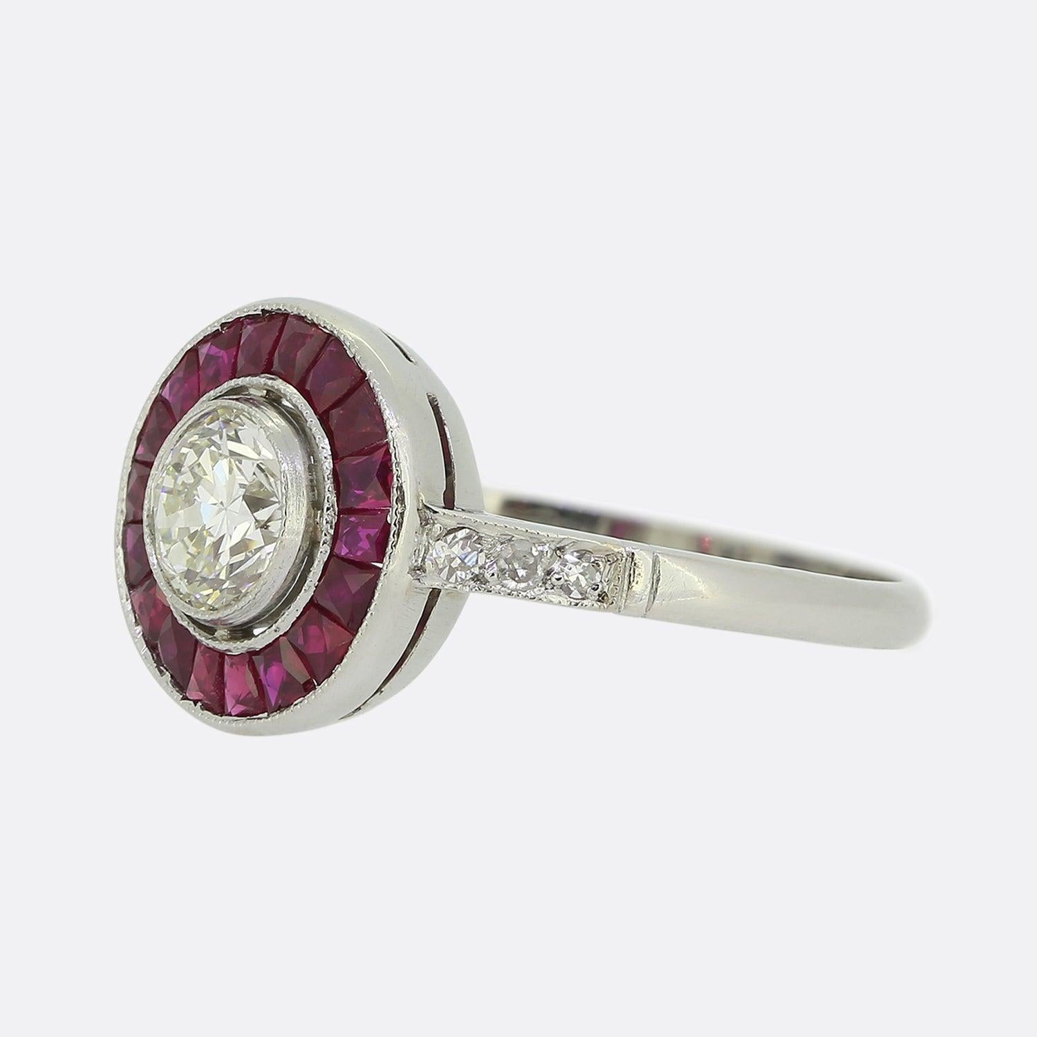 Ecco un anello target con diamanti e rubini di superba fattura che rende omaggio a un classico stile Art Déco. Questo pezzo in platino ospita un singolo diamante rotondo sfaccettato di taglio antico al centro del quadrante. Questa orgogliosa pietra