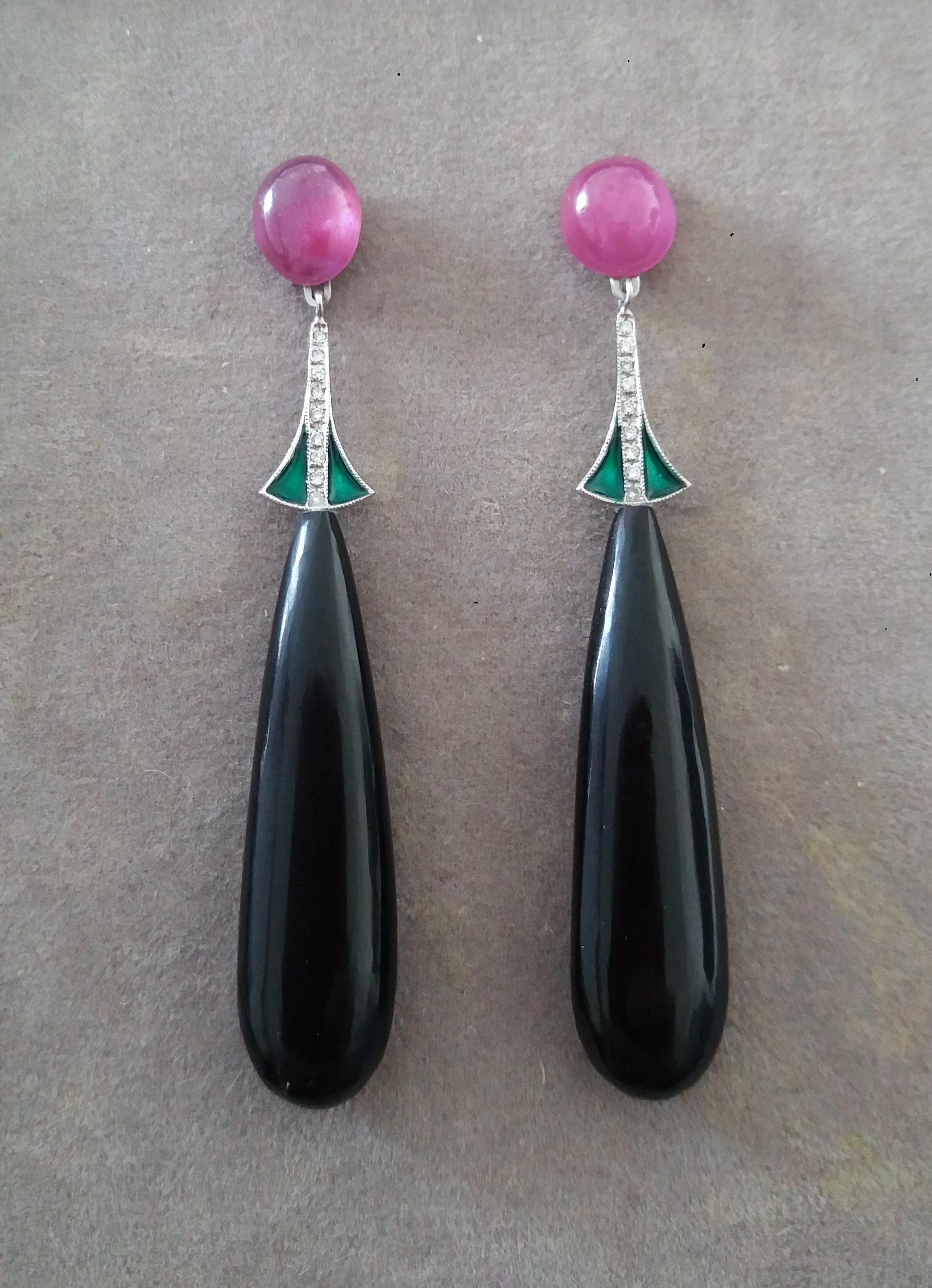 Diese klassischen Ohrringe im Art Deco-Stil bestehen aus 2 ovalen Rubin-Cabochons und 2 Weißgold-Elementen mit Diamanten und grüner Emaille.  an dem 2 lange Tropfen aus schwarzem Onyx mit den Maßen 40x12 mm aufgehängt sind.

1978 begann unser
