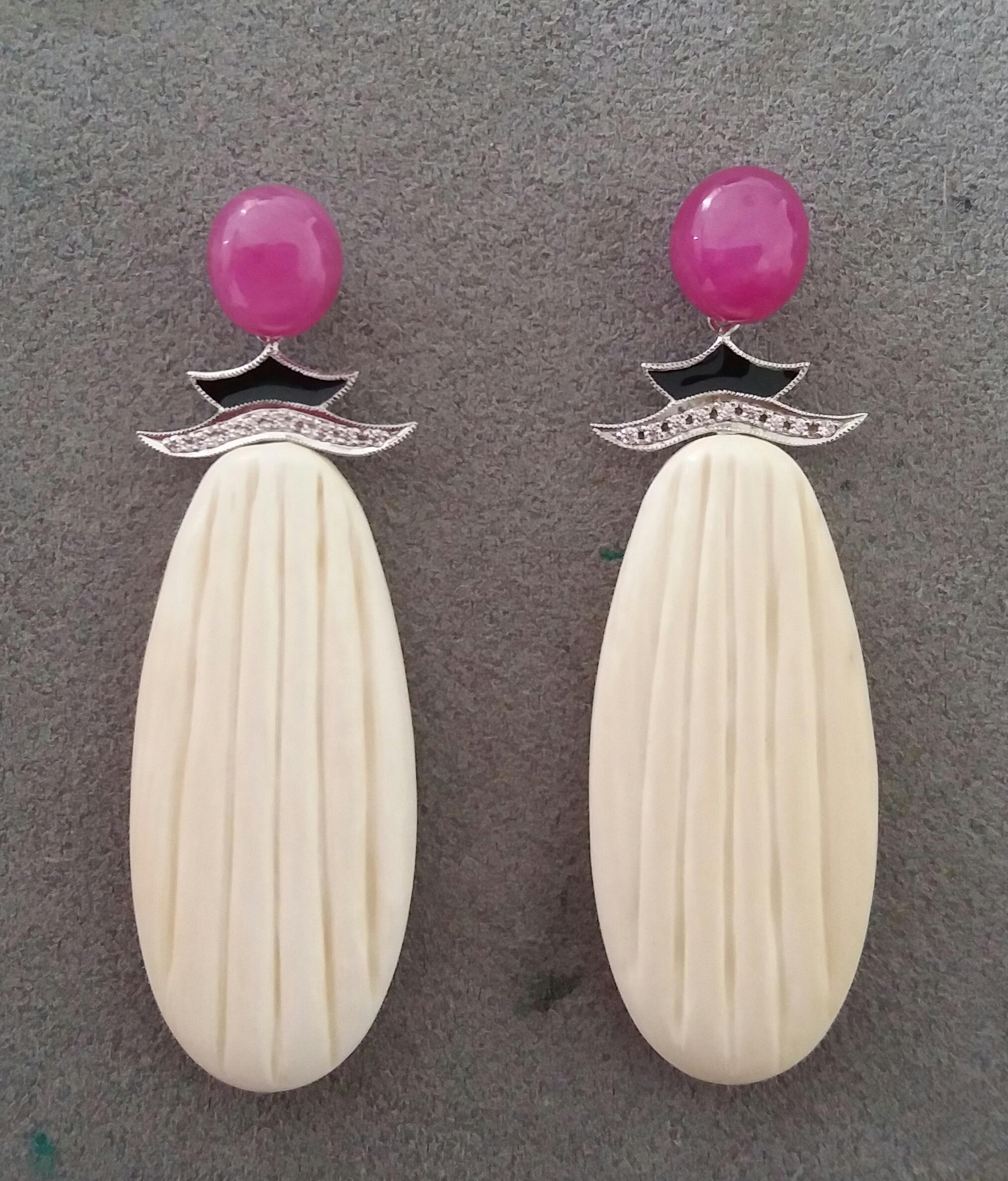 the top has 2 large ruby cabochons, then we have a central part in white gold diamonds and black enamel, finally the bottom part is composed of 2 Mammoth bone engraved flat drops

In 1978 our workshop started in Italy to make simple-chic Art Deco