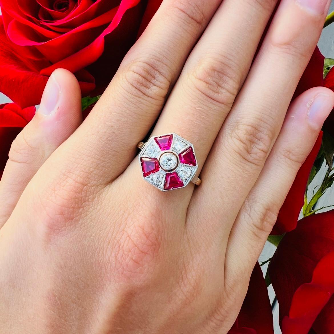 ¡Para los amantes del art déco! Este anillo amarillo y blanco de 18 quilates, de diseño octogonal, presenta cinco diamantes de talla europea y de mina antigua con un peso aproximado de 0,56 quilates, y está acentuado con cuatro rubíes rojos