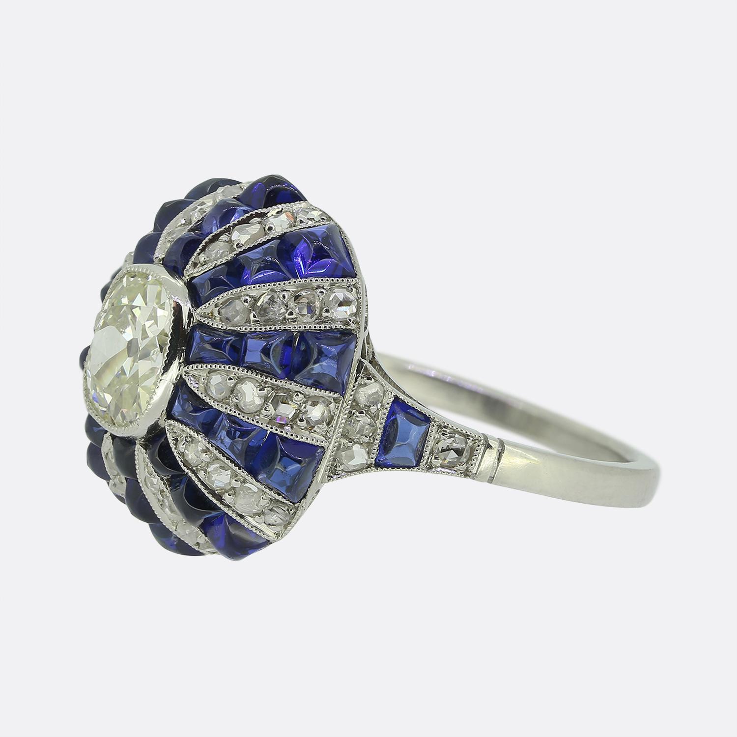Ecco un eccezionale anello bombe che rende omaggio in modo eccellente al classico stile Art Deco. Questo pezzo in platino presenta un singolo diamante ovale sfaccettato di taglio antico al centro del quadrante in una raffinata montatura a grana