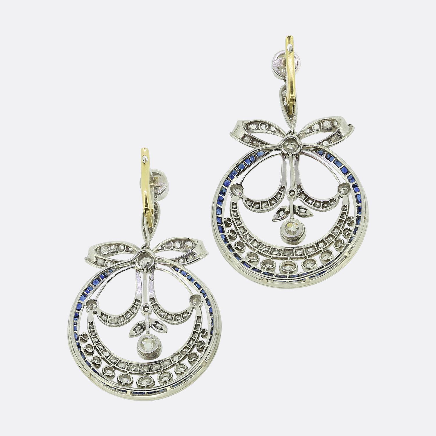 Here we have an outstanding pair of drop earrings excellently crafted from 18ct gold in a typical Art Deco style. A rose cut diamond set bow motif surmounts an open circular frame below consisting of old and rose cut diamonds before a single row of