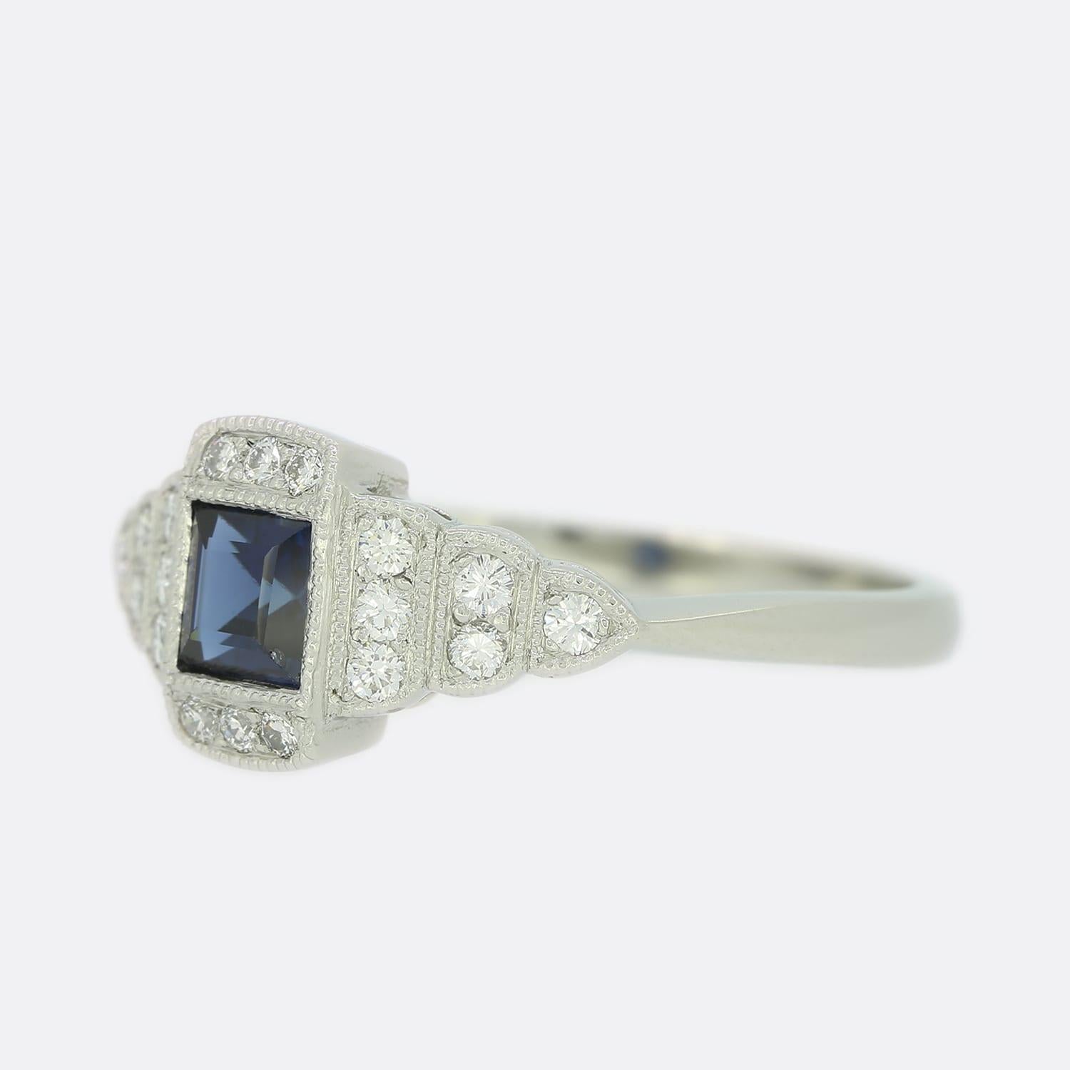 Si tratta di un meraviglioso anello target con zaffiri e diamanti in stile Art Déco. L'anello è stato incastonato con uno zaffiro centrale a taglio quadrato e circondato da un gruppo di diamanti rotondi a taglio brillante in una tipica montatura in