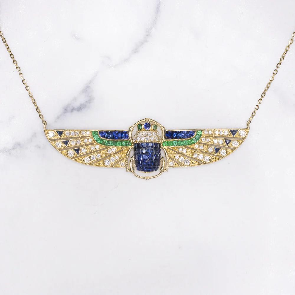 This amazing Pendant is adorned with gorgeously diamonds as well as richly saturated custom cut natural emeralds and sapphires. 
This chic scarab necklace brings to life the glamour of the Art Deco Egyptian revival.
Infact it was inspired by the