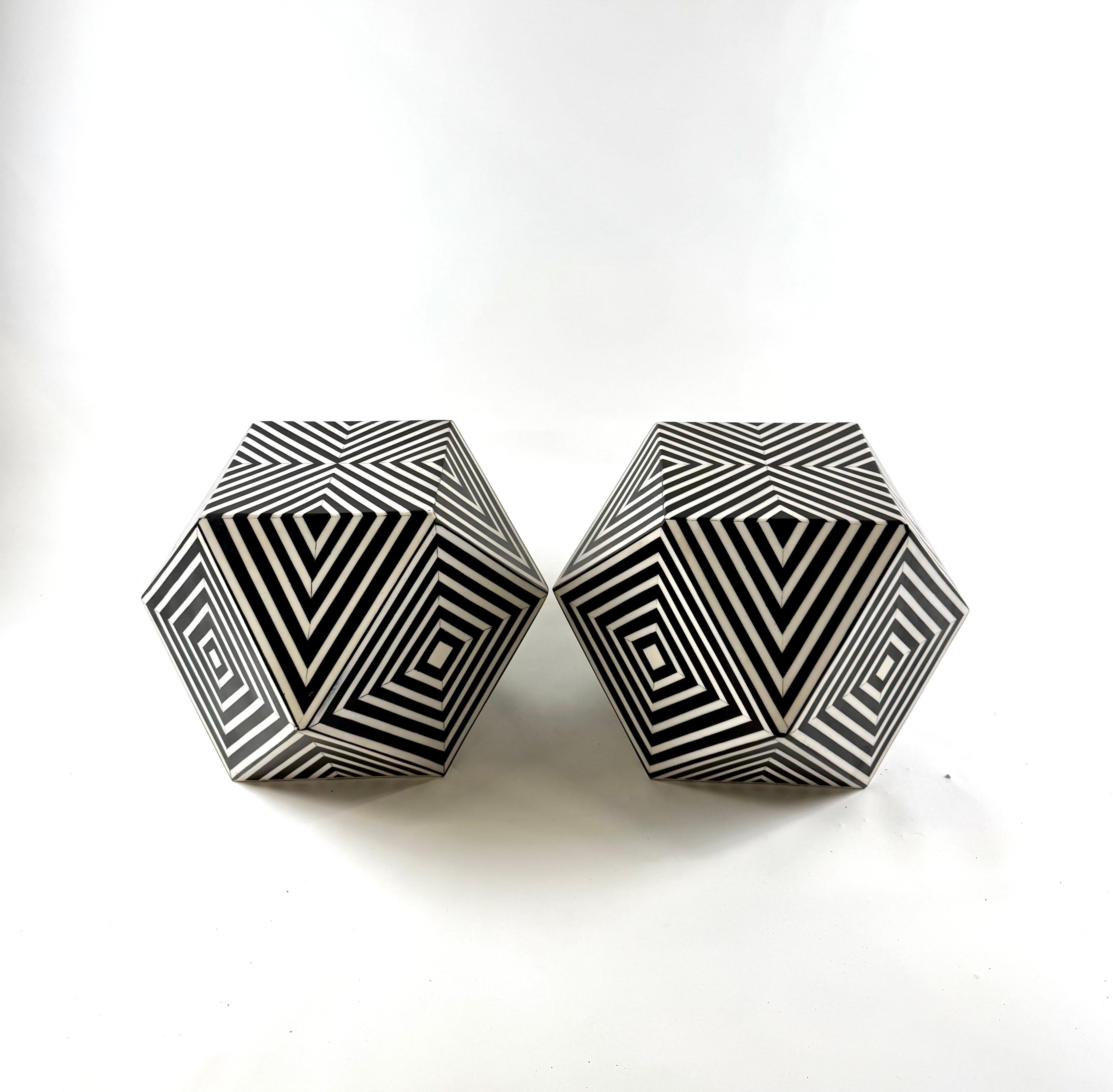 A striking pair of sculptural side tables embodies the bold geometric elegance of Art Deco design, seamlessly fused with a contemporary edge. Crafted from high-quality resin, these hexagonal forms captivate with their mesmerizing black-and-white