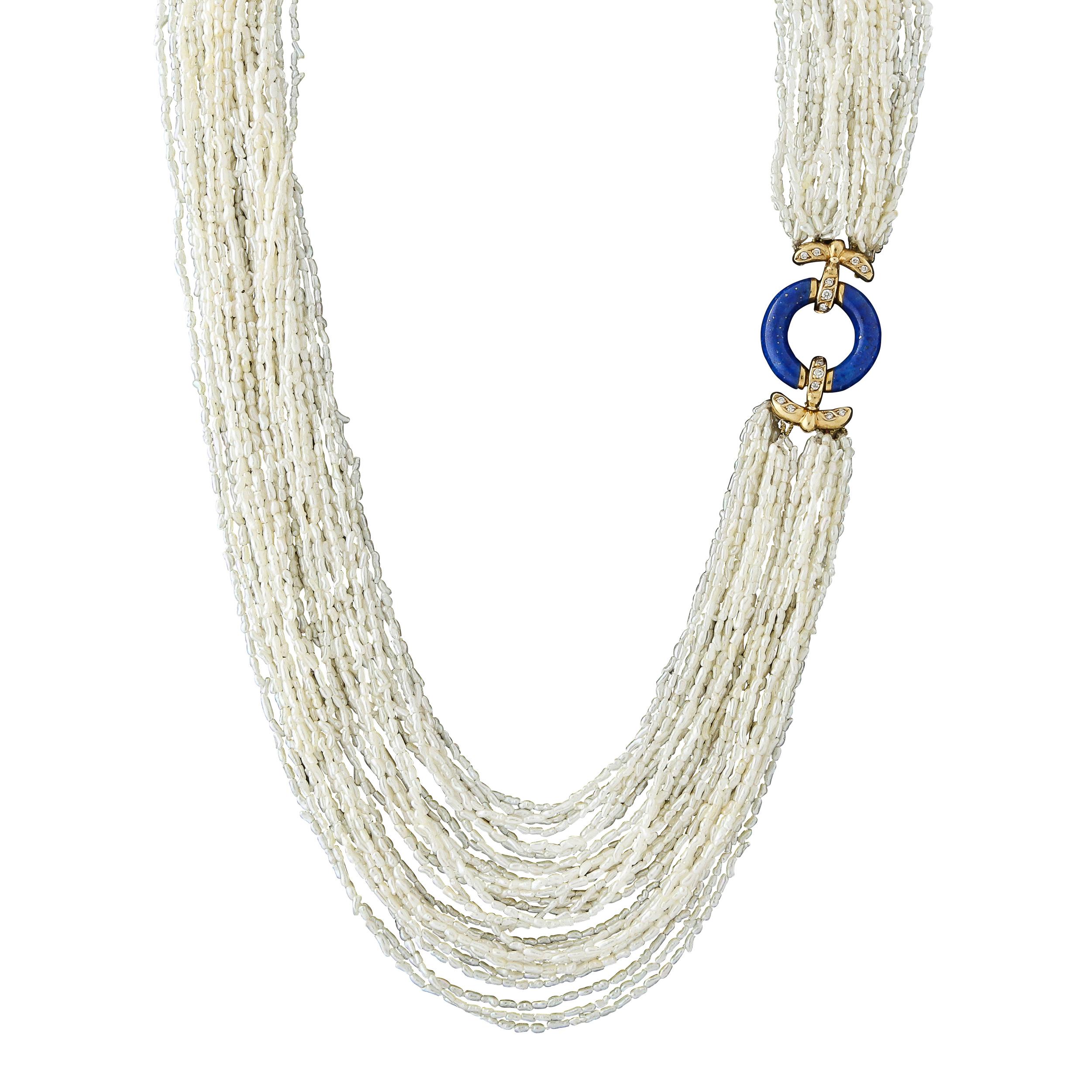 This very elegant multi strand white seed pearl necklace is fitted with a 14k yellow gold clasp set with lapis lazuli and 14 single cut diamonds. The clasp can be worn in the front or in the back which changes the look of the piece to more casual or