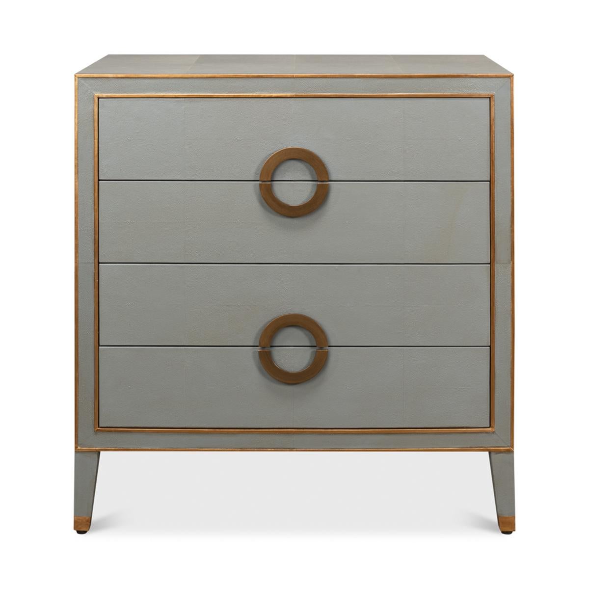 Art Deco style Shagreen chest of drawers. Grey shagreen embossed leather with gold ring handles and trim, with four drawers raised on square tapered legs.

Dimensions: 38