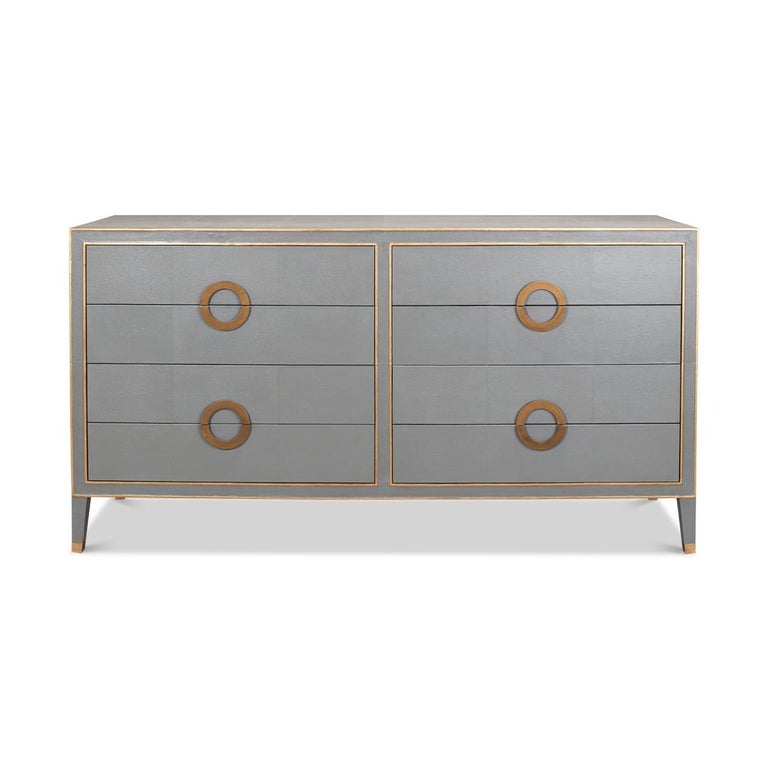 Art Deco Style Shagreen dresser. Grey shagreen embossed leather with gold ring handles and trim, with eight drawers raised on square tapered legs.

Dimensions: 76