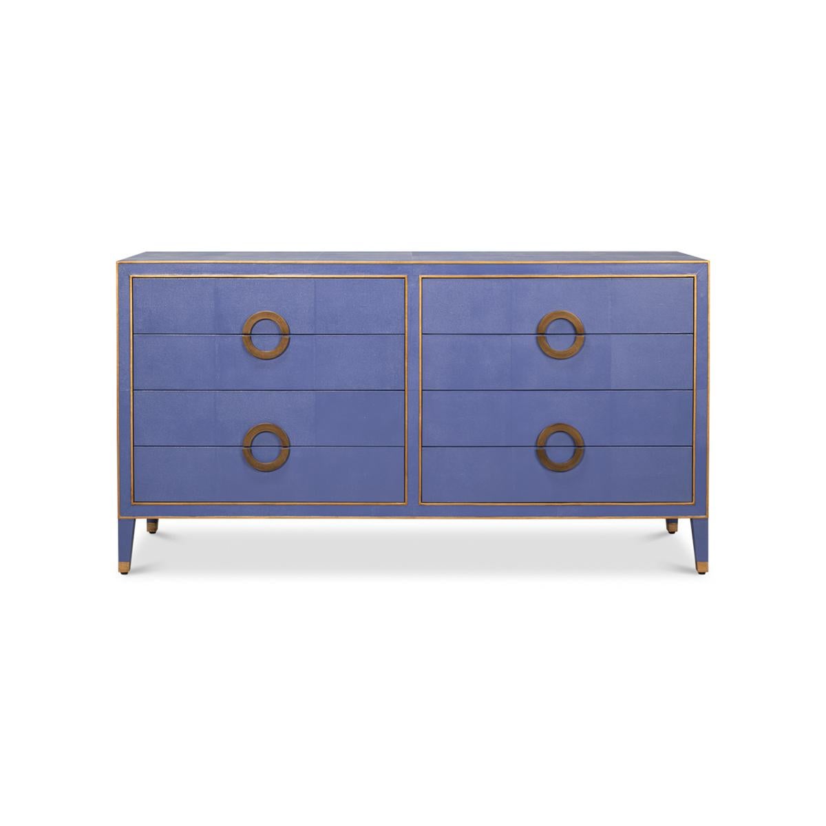 This exquisite piece features a rich cobalt blue shagreen embossed leather, which exudes an air of sophistication and luxury. The dresser is adorned with elegant gold ring handles and trim, adding a touch of glamour to its overall design.

With