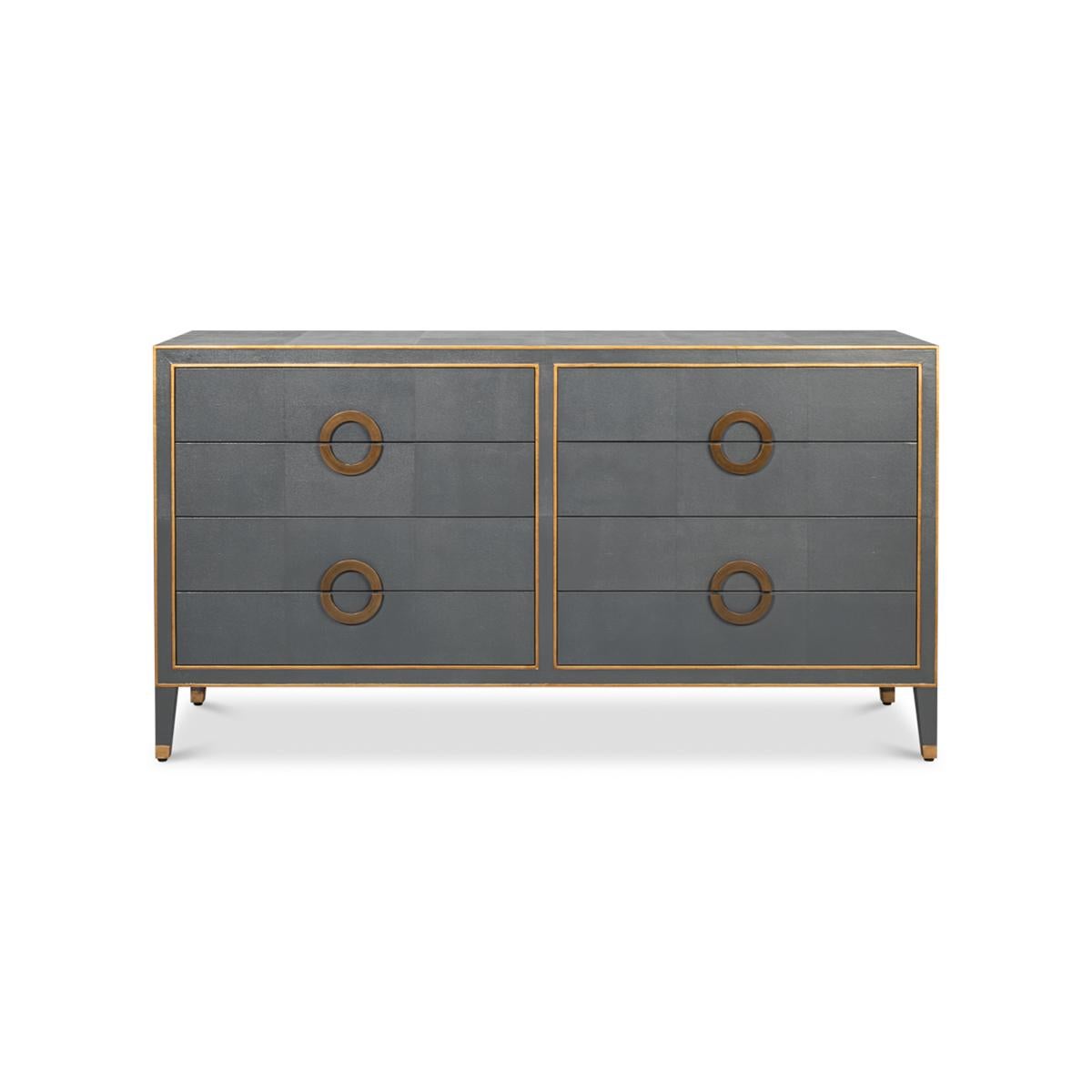This exquisite piece features a rich gun metal or pewter grey shagreen embossed leather, which exudes an air of sophistication and luxury. The dresser is adorned with elegant gold ring handles and trim, adding a touch of glamour to its overall