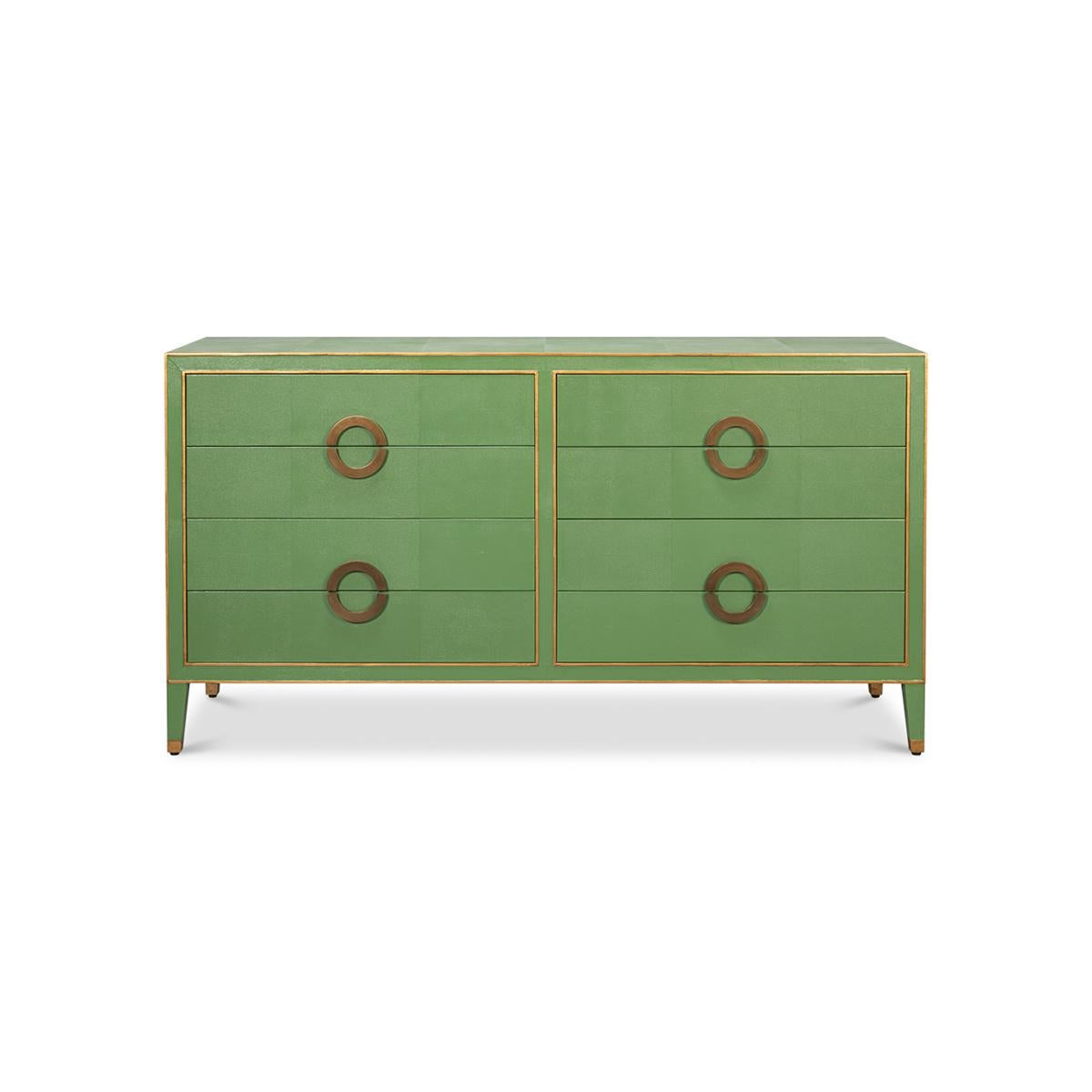 This exquisite piece features a rich green shagreen embossed leather, which exudes an air of sophistication and luxury. The dresser is adorned with elegant gold ring handles and trim, adding a touch of glamour to its overall design.

With eight