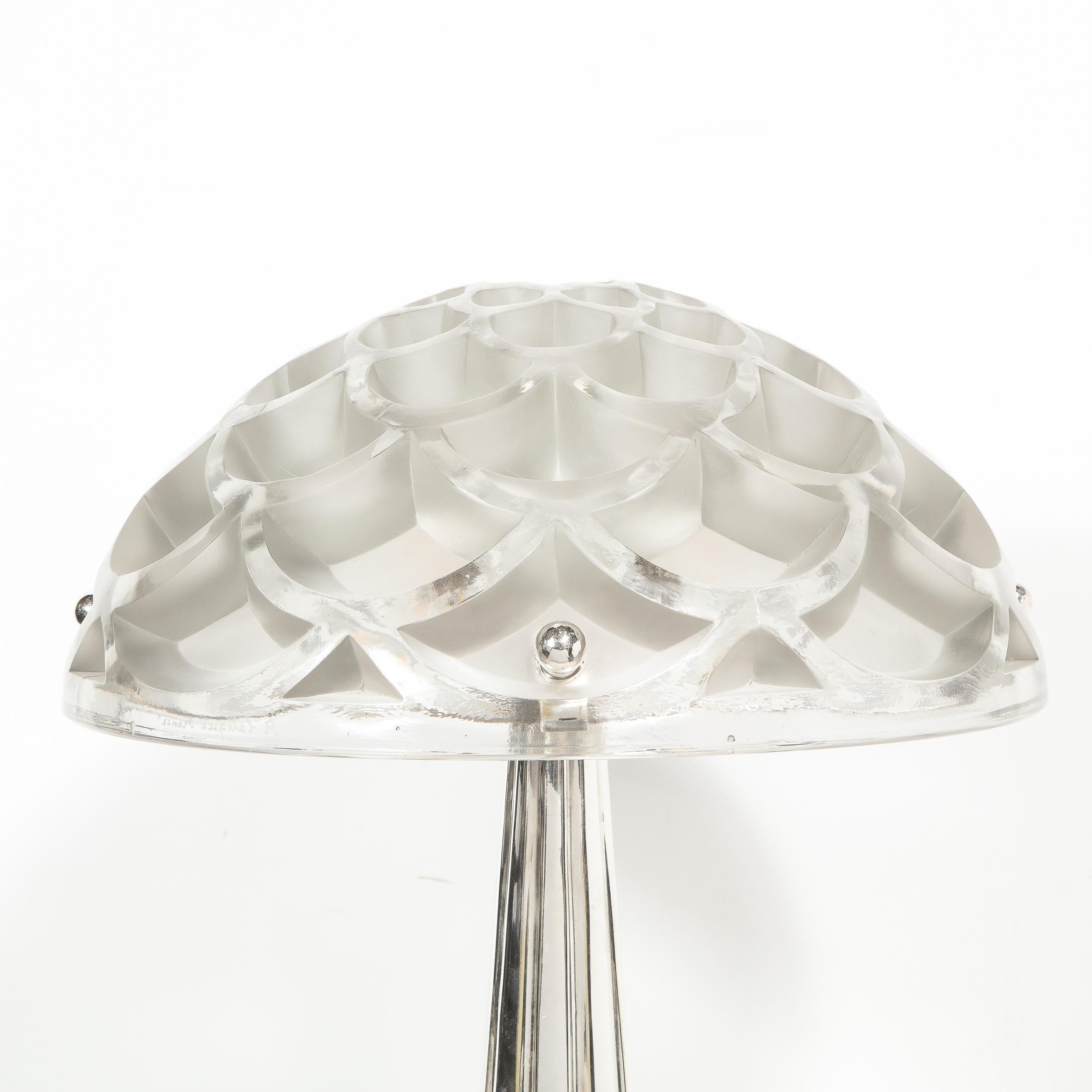 This stunning Art Deco style lamp was realized by the illustrious studios of René Lalique- one of the most celebrated designers in the history of glass making in France. It features a tiered circular base whose top is finely striated with a sunburst
