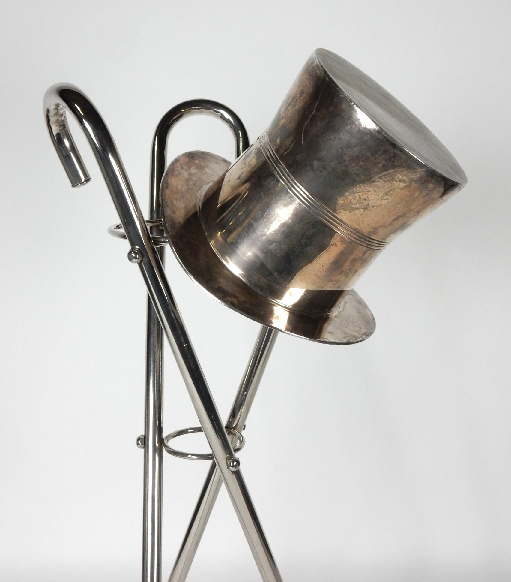 Wonderful vintage 1970's silvered champagne ice bucket shaped like a 
gentlemen's top hat with a tripod walking cane stand.
Bucket formed of solid brass with silverplate.
Cane stand is chrome plated steel.
This set shows nice aged patina from