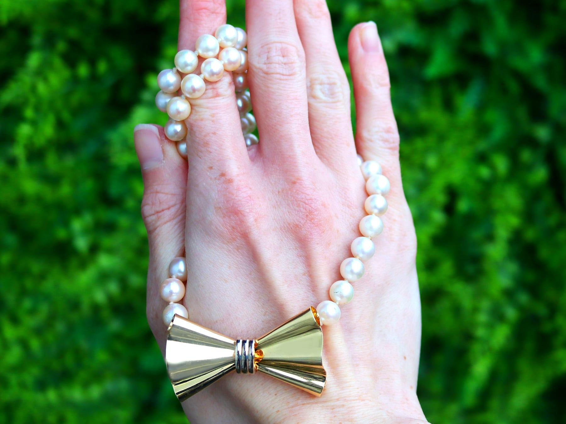A fine and impressive vintage single strand, opera length, cultured pearl necklace with an 18 karat yellow gold and 18 karat white gold clasp; part of our diverse jewelry and estate jewelry collections.

This fine and impressive opera length