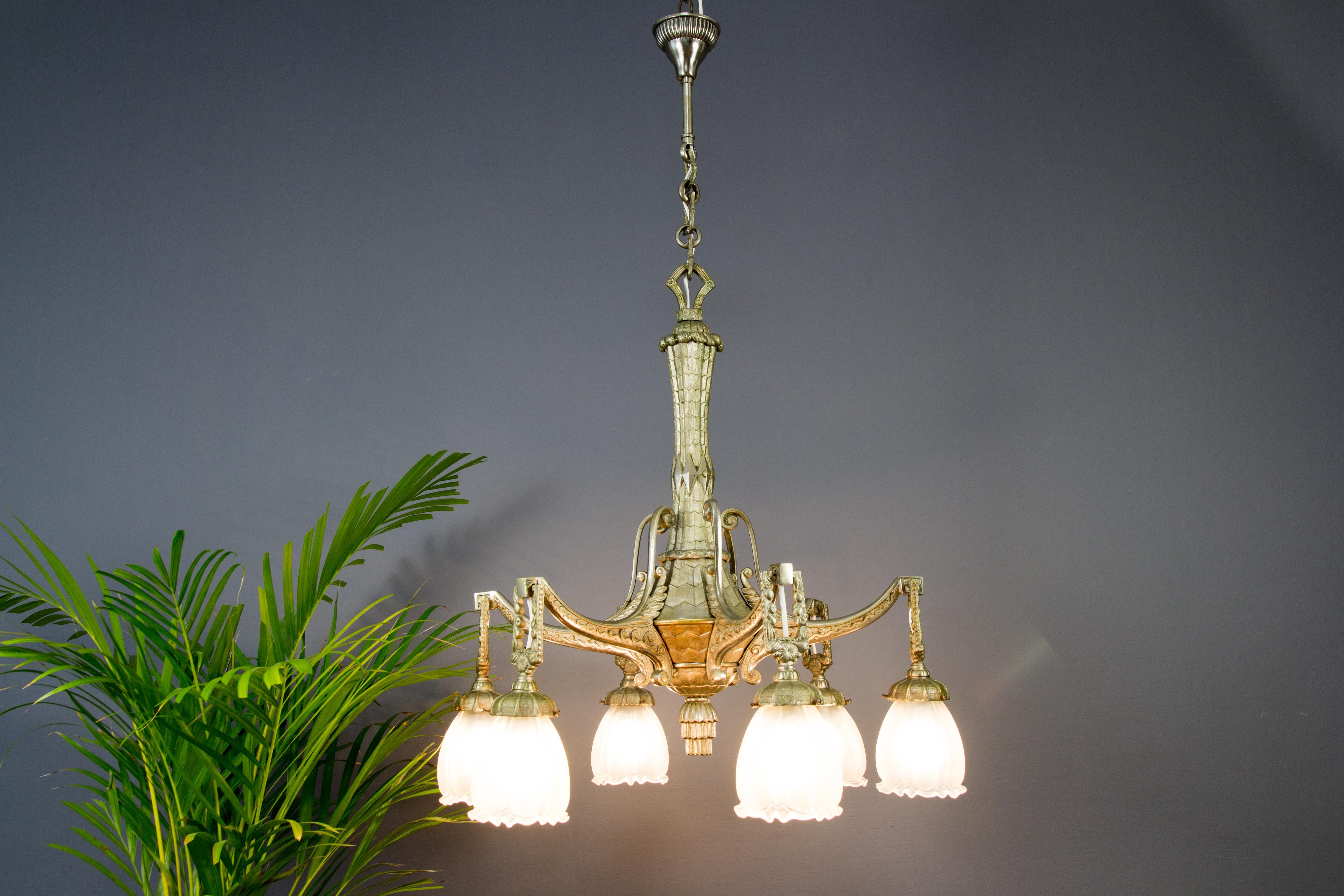 Beautiful French Art Deco style silver color bronze chandelier from the 1920s. Six bronze arms decorated with Art Deco ornaments, each with frosted glass lamp shade and a socket for E 27 (E26) size light bulb.
Measures: Height is 36.22 inches / 92