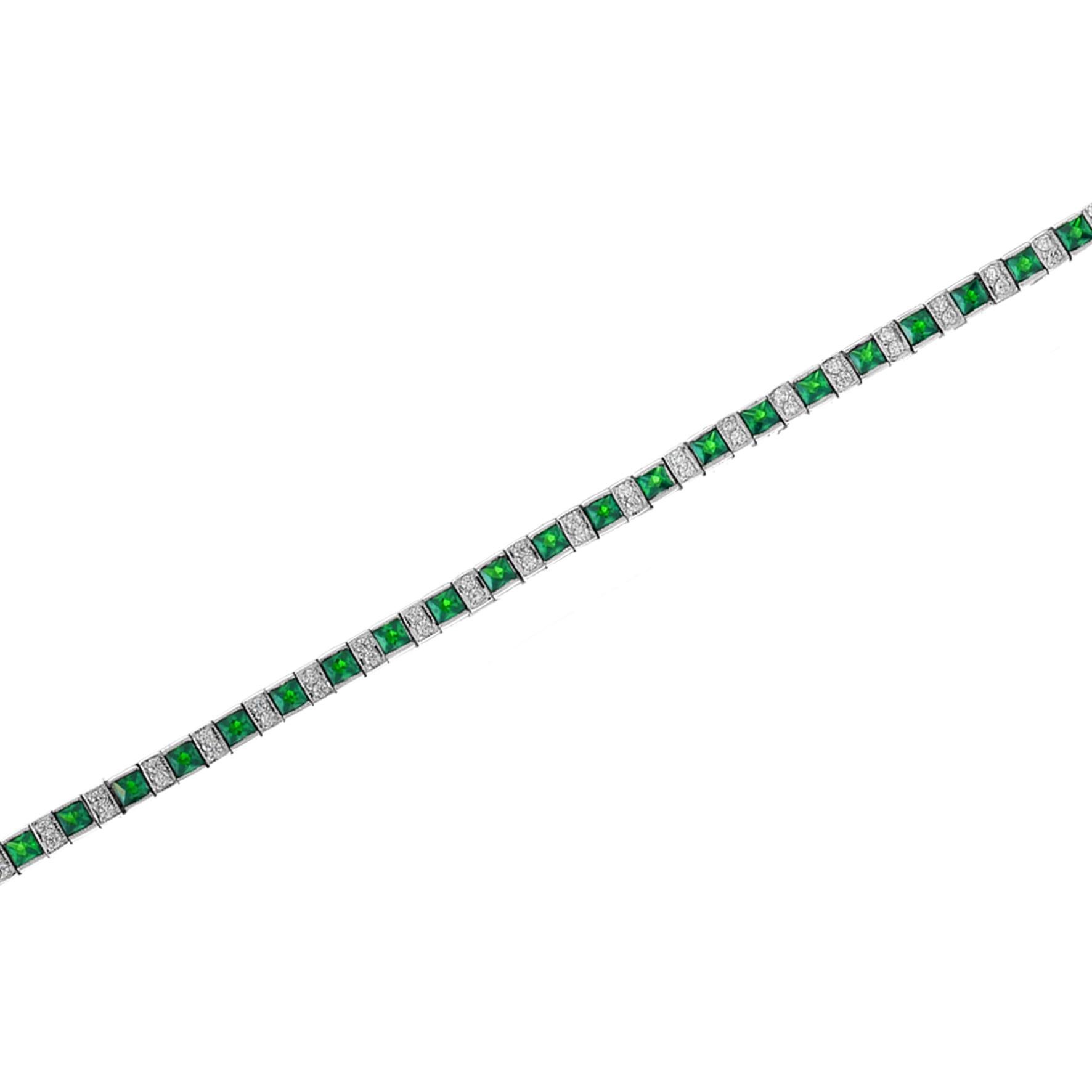 A gorgeous gemstone line bracelet from the Art Deco era! , this fabulous piece features an alternating pattern comprised of sections of emeralds and diamonds. The bracelet fastens at a push clasp seamlessly hidden within the final link, and a hinged