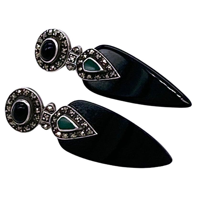 This is a pair of Art Deco style sterling silver drop earrings. These black and green agate teal drop post earrings have hinges connecting two decorated marcasite oval and pear shaped sterling segments. Stamped 925 on the back.

Our vintage jewelry