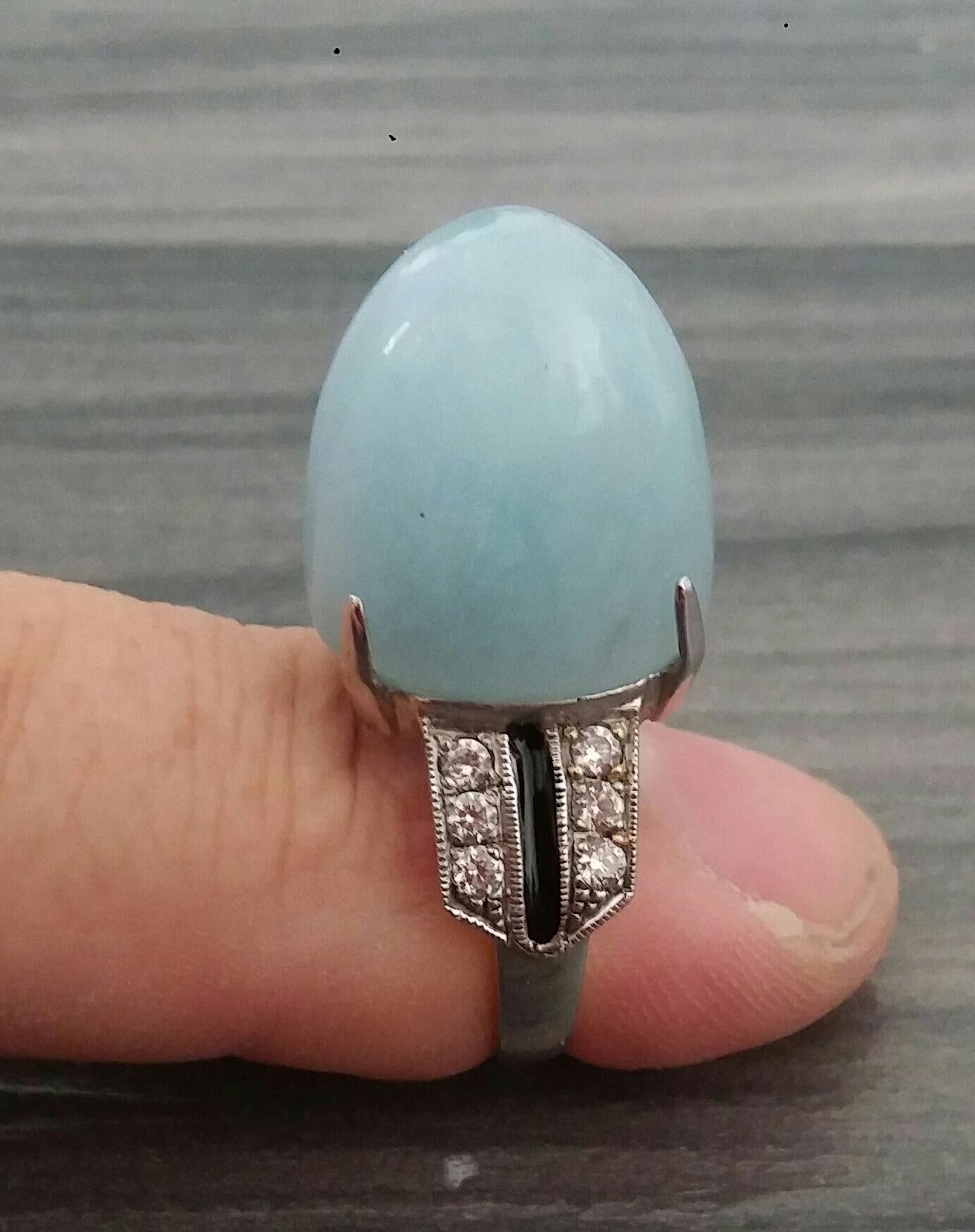 28 Carat Sugar Loaf Aquamarine cab ( 16,5 mm. x 13 mm.x17 mm.) ,12 round full cut diamonds of 0,05 ct. each,for total diamonds weight of 0,6 carat.4.7 grams of 14 kt. white gold,black enamel
Ring Shank Diameter  21 mm
Height 28 mm
Weight  9 grams
In