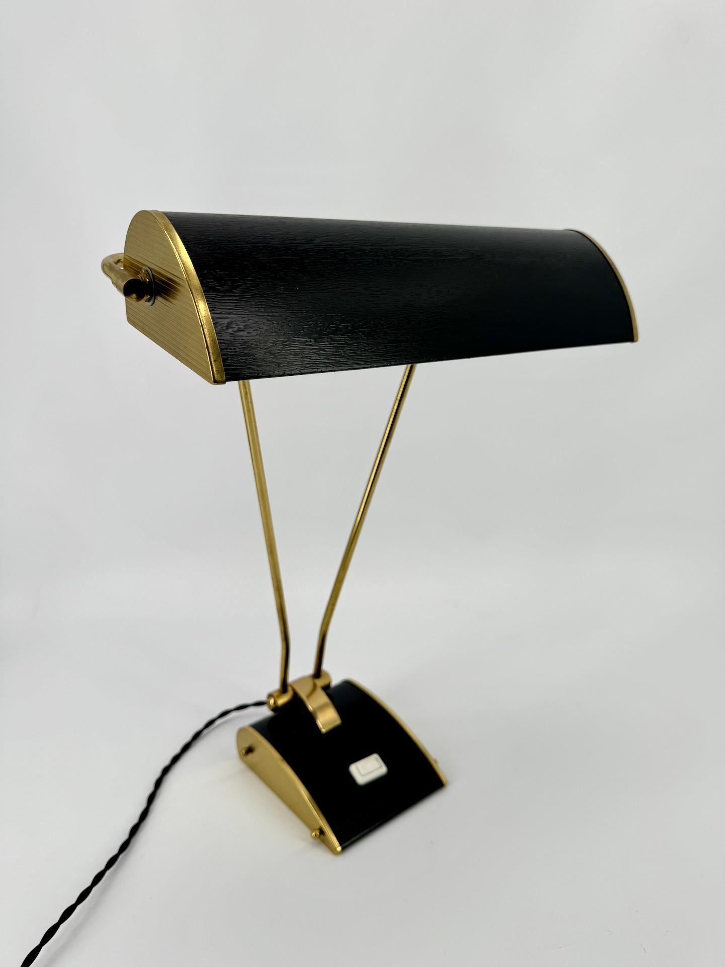 Art Deco mid-century JUMO lamp in streamline black and brass finish.

The company JUMO (contraction of the first two letters of the 3 creators Yves JUjeau and Pierre and André MOunique) was created in 1940. The company produced lighting until the