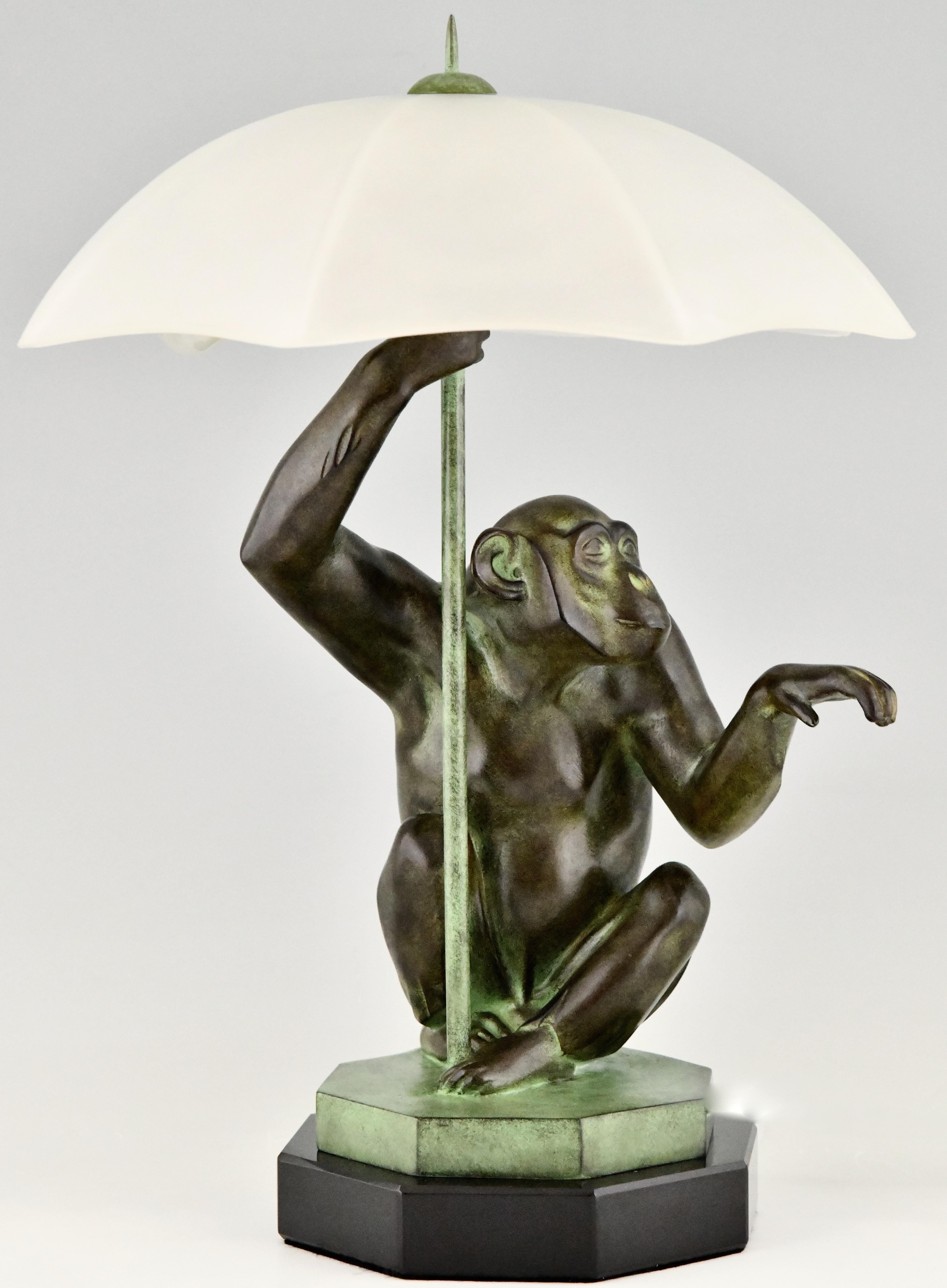 Scimmia da lampada in stile Art Deco con ombrello PLUIE di Max Le Verrier. 
Metallo patinato su base di marmo, paralume a ombrello in vetro smerigliato. 
Design 1927. 
Fusione contemporanea postuma presso la fonderia Le Verrier di Parigi. 
Con