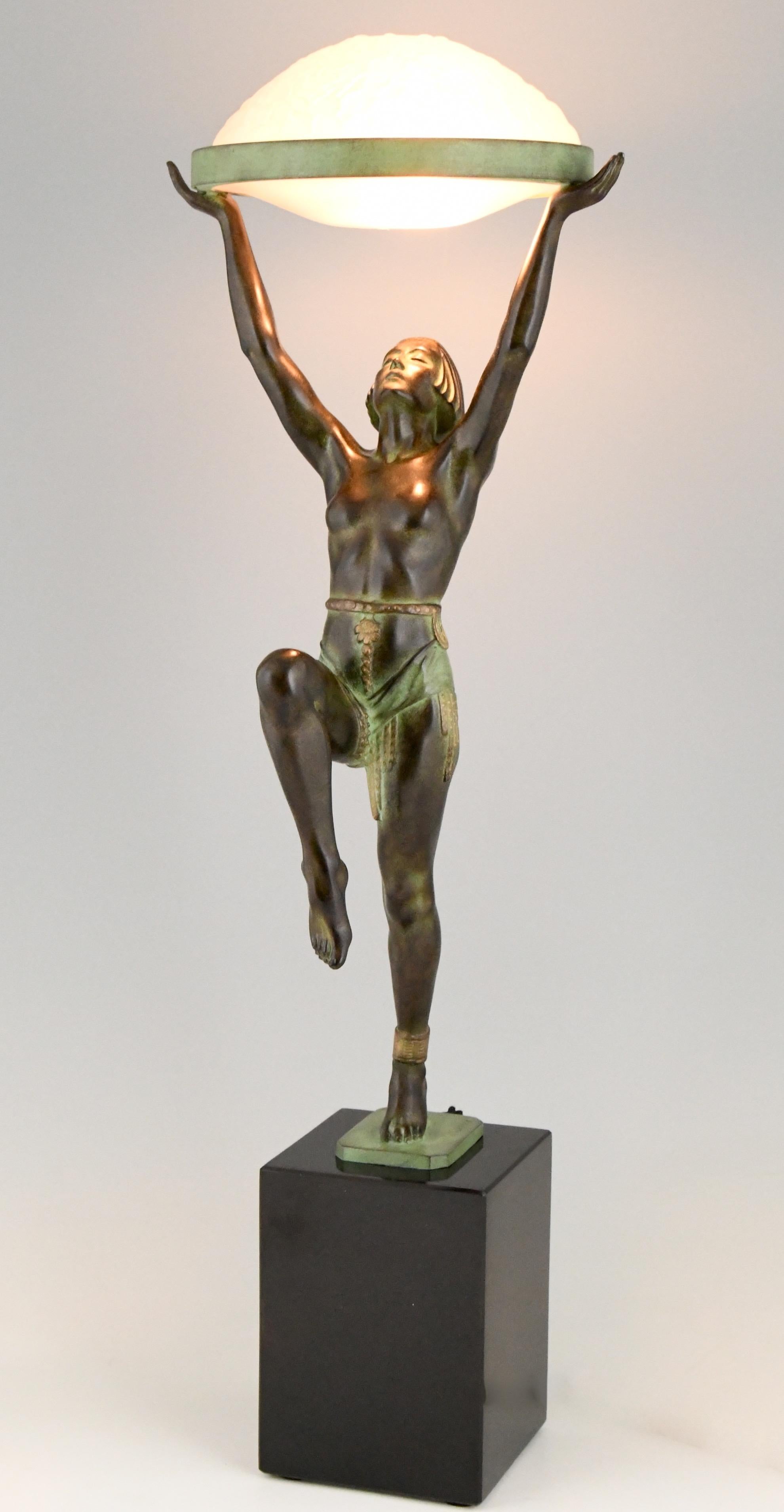 Figürliche Tischlampe im Art Deco-Stil mit einer Dame, die einen Glasschirm hält. 
Die Lampe ist signiert und trägt die Gießereimarke von Le Verrier. 
Entwurf ca. 1930, zeitgenössischer posthumer Guss in der Gießerei Le Verrier in Paris,