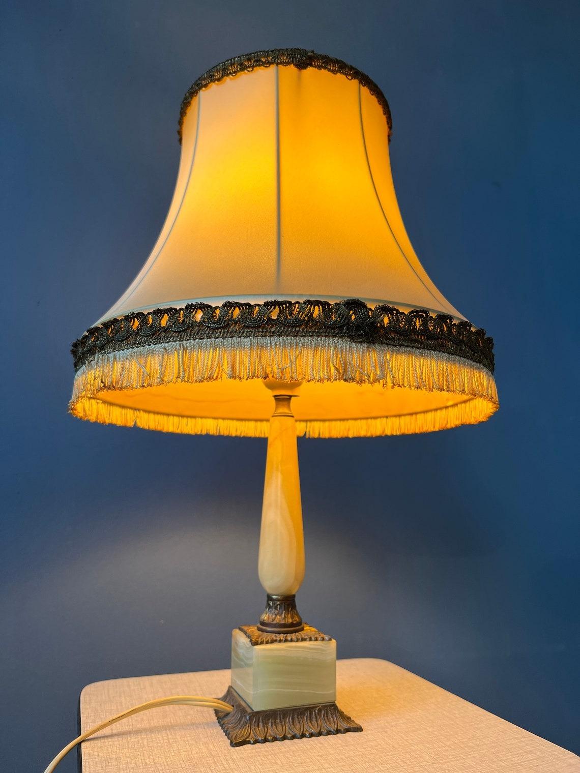 Vintage art deco style table lamp with marble base and textile shade. The lamp requires one E27/26 lightbulb and currently has an EU-plug.

Additional information:
Materials: Linen, metal, stone
Period: 1970s
Dimensions: ø Shade: 22 cm
Height Shade: