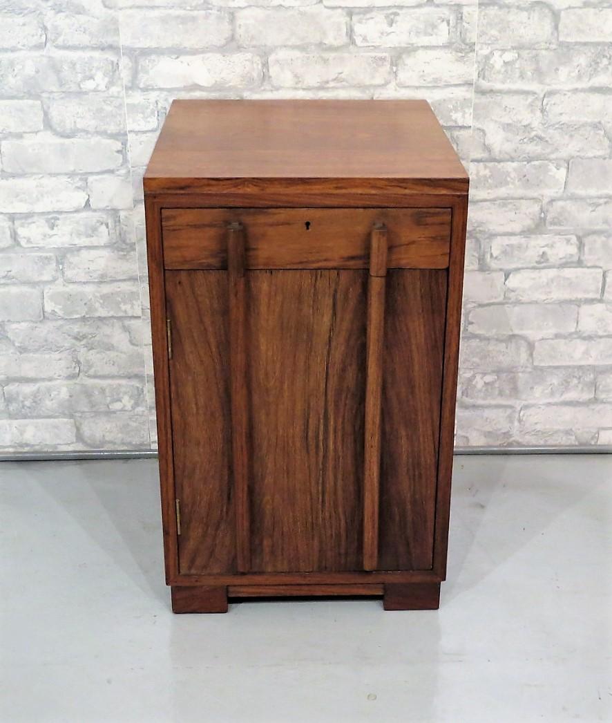 An Art Deco style teak wood cupboard made in the 1950s by a high quality cabinet maker, the piece is nice and heavy, set on block feet with full length handles, we believe it was made in India as the lock suggests but may well be from the