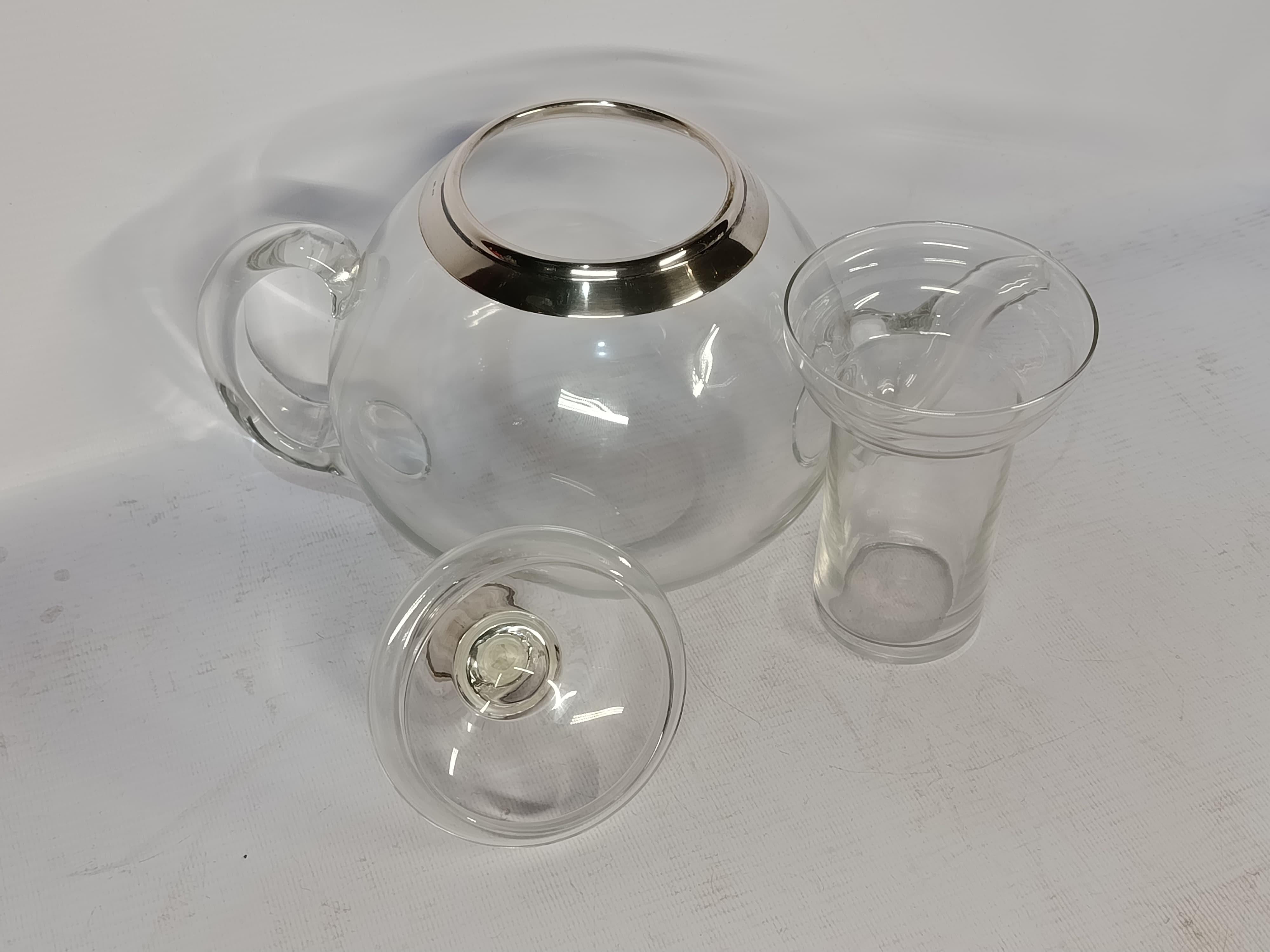 Théière de style Art déco avec infuseur, Allemagne, vers 1950

Élégante théière avec infuseur en verre soufflé selon des techniques artisanales traditionnelles. D'origine allemande, cette pièce allie le verre et l'argent, avec un poinçon 