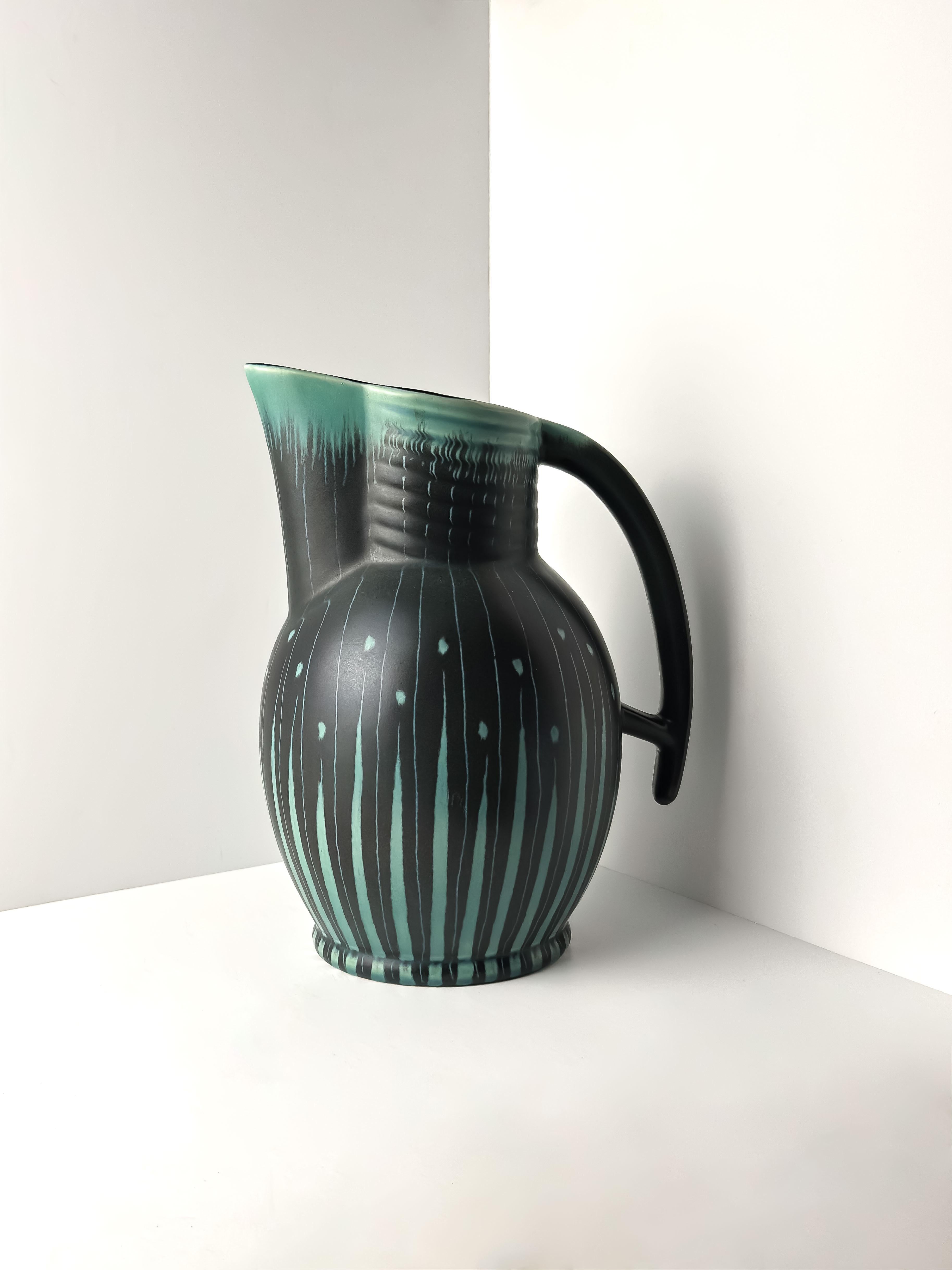 Esta jarra de cerámica de estilo Art Déco, diseñada por Colin Melbourne para Beswick, Inglaterra, es un audaz ejemplo del diseño modernista de mediados de siglo. Concebida originalmente por el ceramista de Beswick, el Sr. Symcox, en la década de