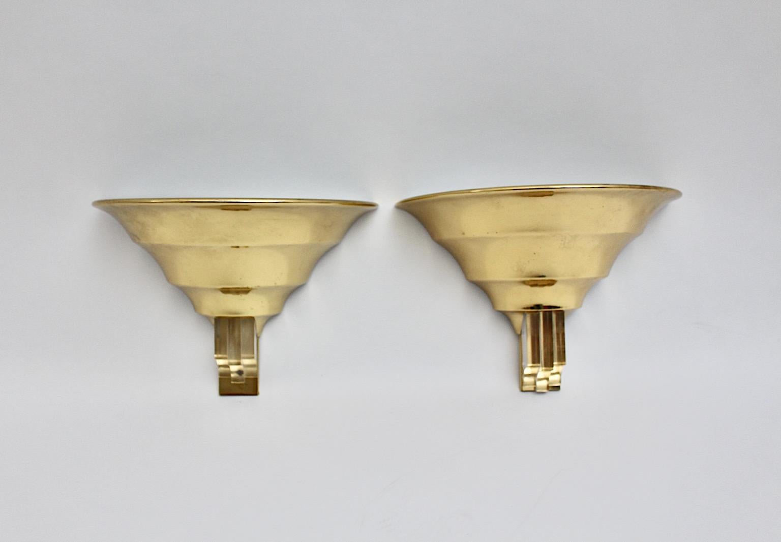 Art Deco Style vintage pair of sconces or wall lights from brass and lucite 1980s Italy.
An amazing duo pair of Art Deco style sconces with a conical grooved shape and decorated at the bottom with lucite. The material lucite points out the elegant