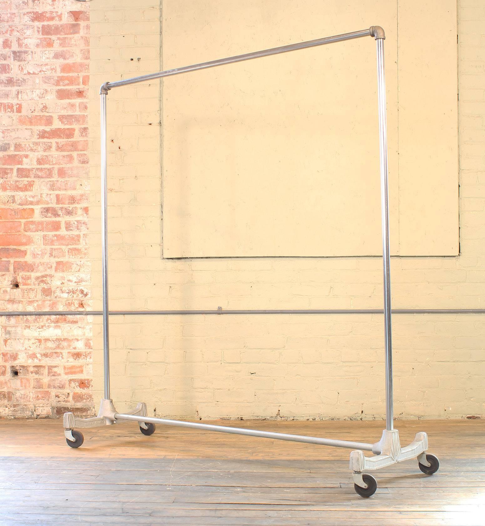 Vintage clothiers rack, rolling garment rack. Made from cast aluminium, steel and iron. Reads 