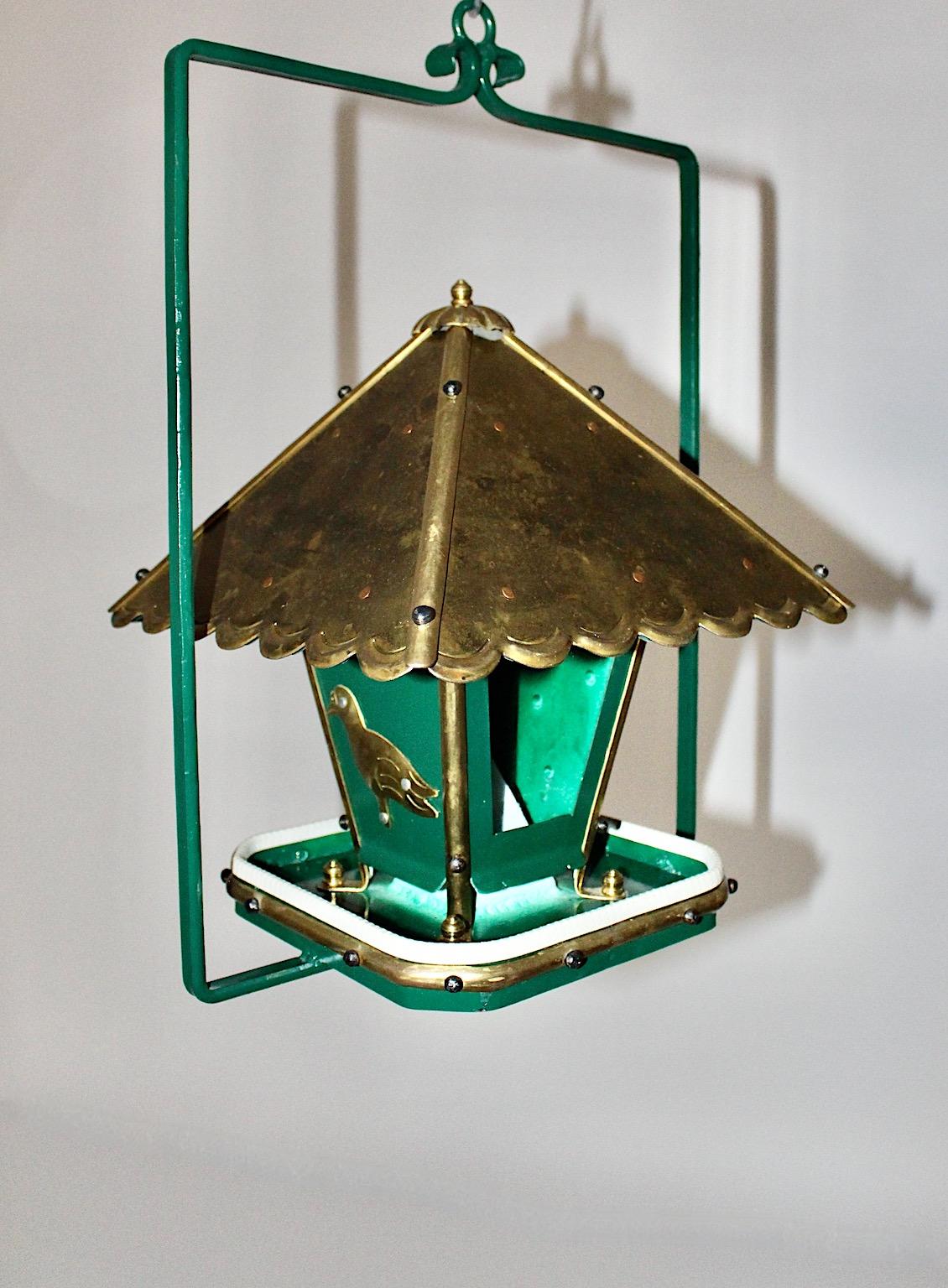 Art Deco style vintage handmade birdhouse from green metal, brass and copper 1980s Austria.
This unique and handmade vintage birdhouse shows a swiveling roof with amazing pagoda details, easy to fill in the seeds. Extra details as bird figures from