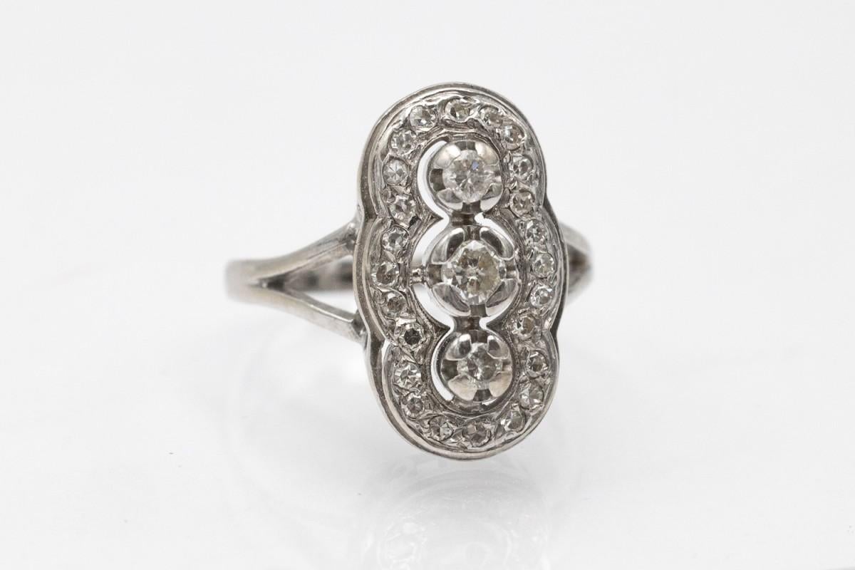 Elegant, elongated ring made of 18-karat white gold (750 fineness). Three main diamonds in a brilliant cut with a total weight of 0.35 ct (H-J color, VS-P clarity). Additionally, the ring is decorated with 24 diamonds in an 8/8 cut with a weight of