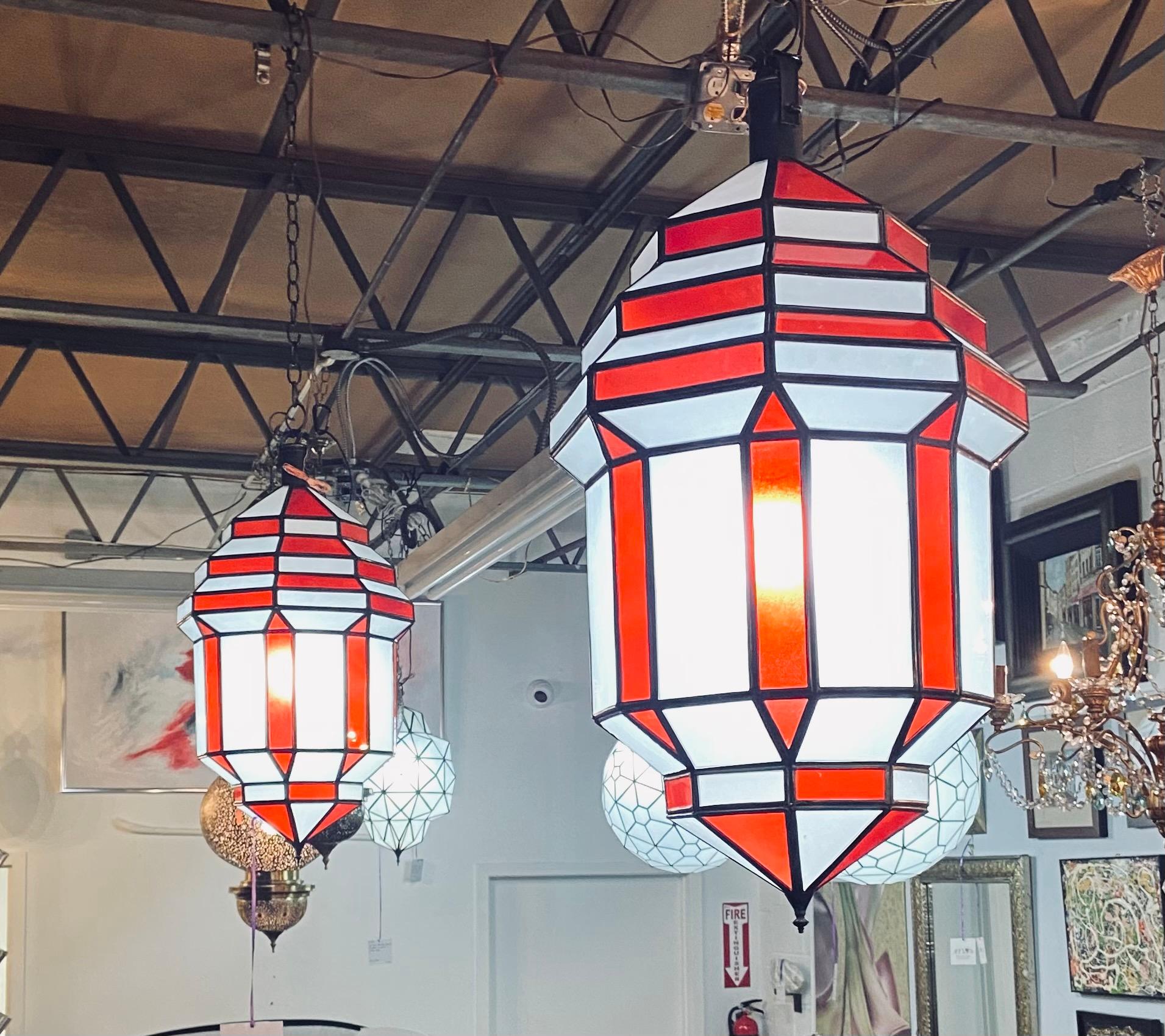 Art Deco style white milk and red glass chandelier, pendant or lantern, a pair
A gorgeous handcrafted, having individual panes, pair of Art Deco hanging lanterns or ceiling fixtures featuring sandblasted frosted milky white and red glass and