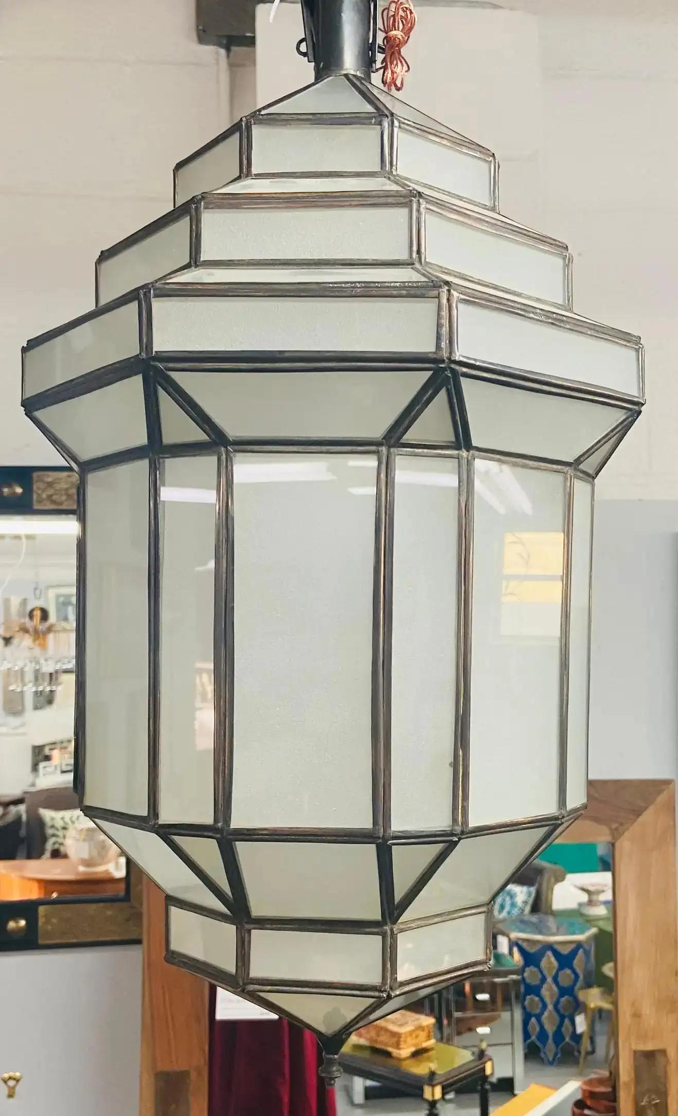 Art Deco style white milk glass handmade chandelier, pendant, lantern, a pair.
A gorgeous handcrafted with individual panels, this pair of Art Deco hanging lanterns or ceiling fixtures features sandblasted frosted milky glass and patinated metal