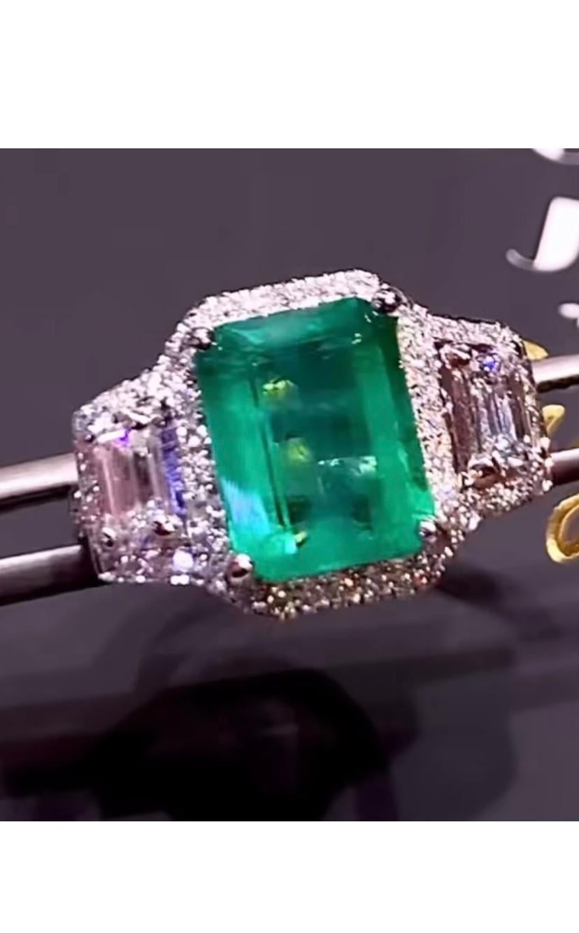 An exquisite Art Deco design, so gorgeous and chic, a very glamour ring handmade, in 18k gold with a natural Zambia emerald of 3,43 carats,
fine quality, and 2 pieces of emerald cut diamonds and round brilliant cut diamonds of 1,04 carats, F/VS( top