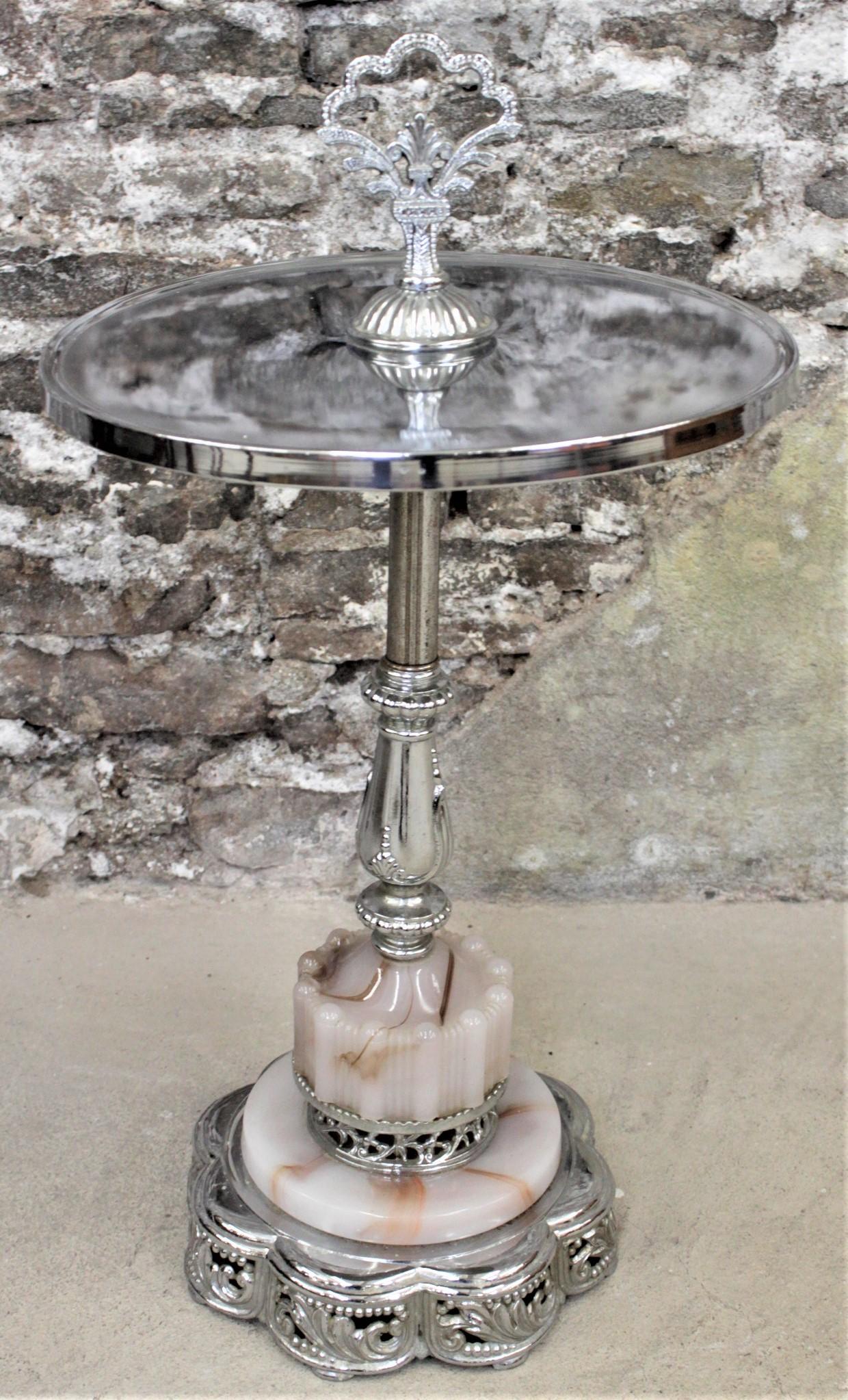 Dating from the mid-20th century, and done in an Art Deco style, this chrome and swirled alabaster colored glass smoker's stand is unsigned, but presumed to have been made in the United States. The stand has a functional and decorative chrome handle