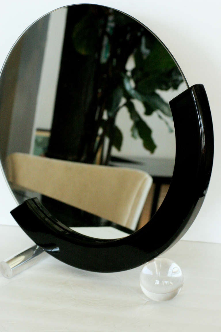 Art Deco styled half moon table mirror with chromed steel leg and acrylic ball foot, the free floating mirror is fixed to a lacquered oak base,

circa 1970s.