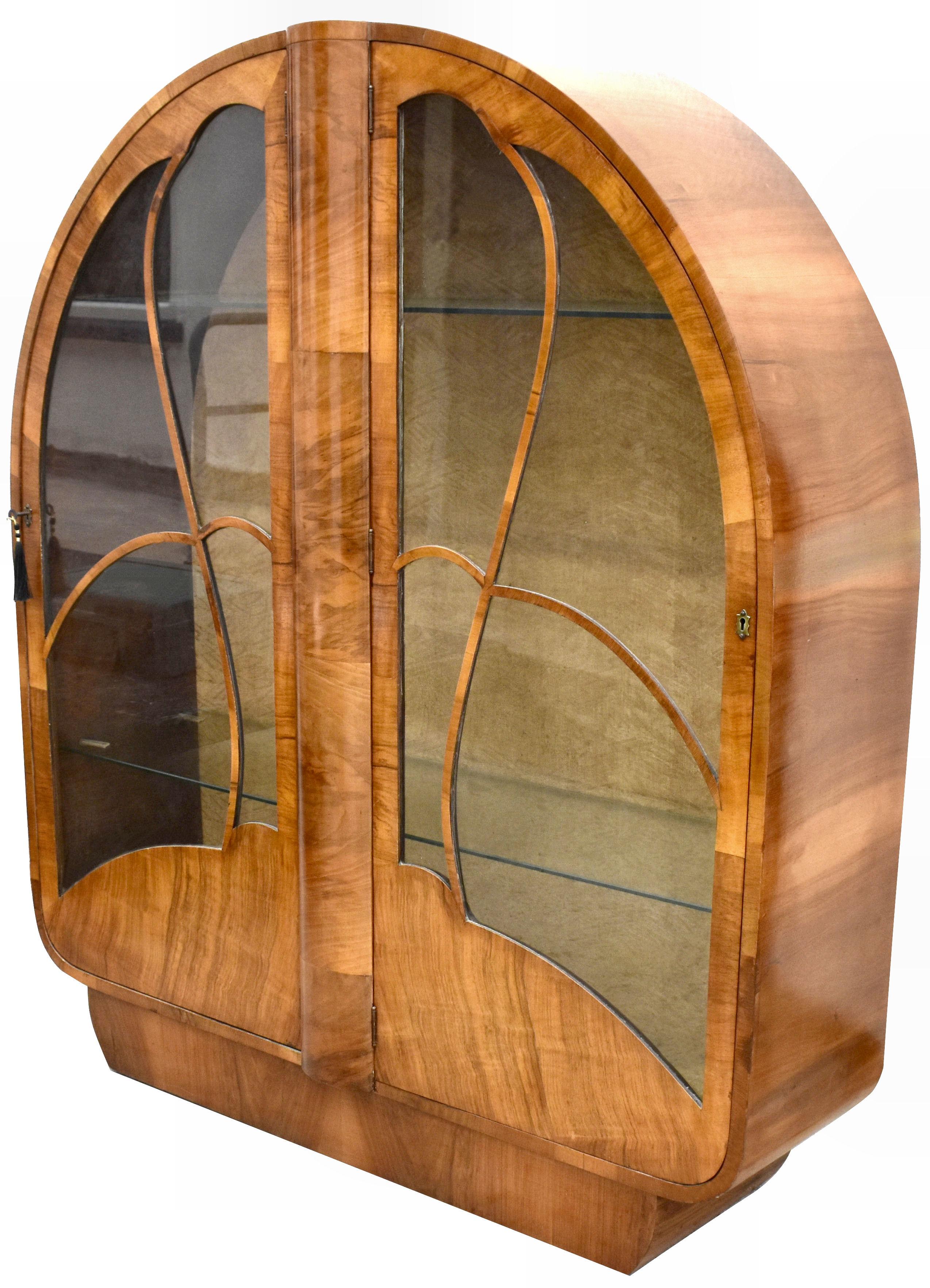 Beautiful and original 1930s Art Deco English walnut display cabinet. A lovely piece of furniture that's veneered in figured mid tone walnut. Still retains its original silk interior backing with a Deco pattern. Original keys which work smoothly to
