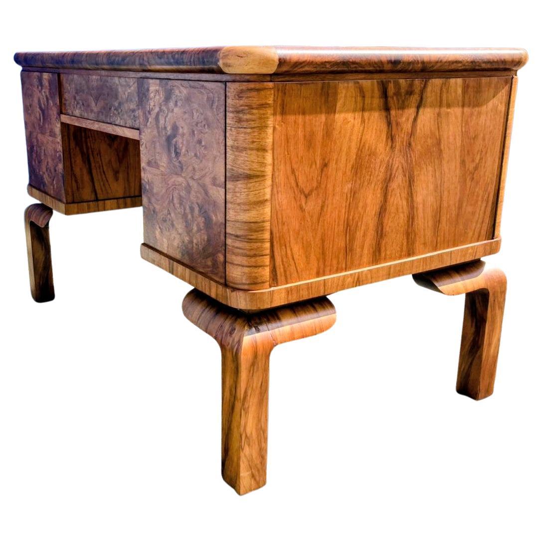 Nous vous proposons cet impressionnant bureau en noyer blond, totalement original, datant des années 1930 et reposant sur des pieds à épaulement rond. Originaire de France, il offre non seulement une fonctionnalité, mais aussi un attrait pour les
