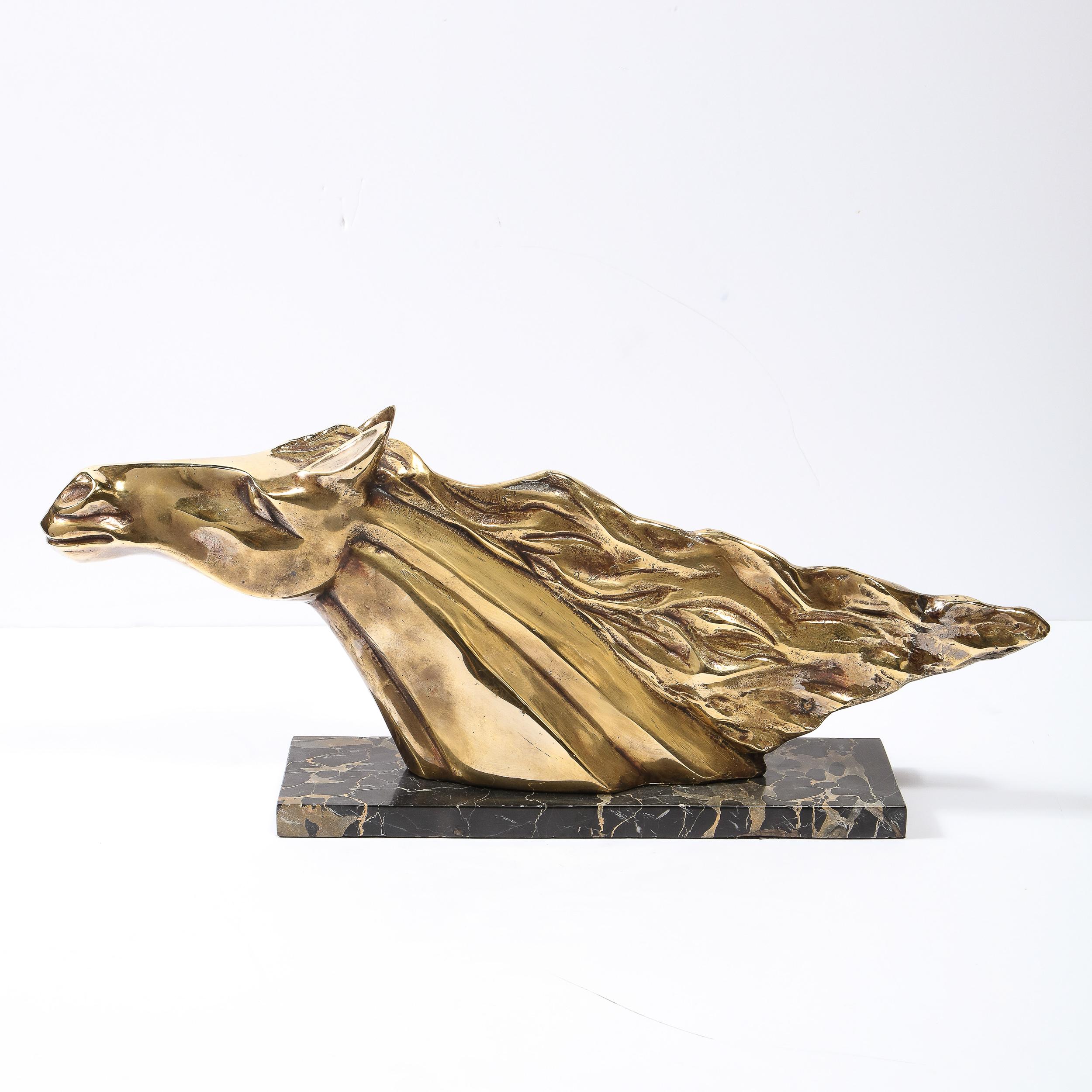 This stunning Art Deco stylized stallion sculpture was realized in France circa 1940. It features an equine form with a flowing mane hand sculpted in lustrous polished brass and presented on a volumetric rectangular pedestal in exotic black Portoro