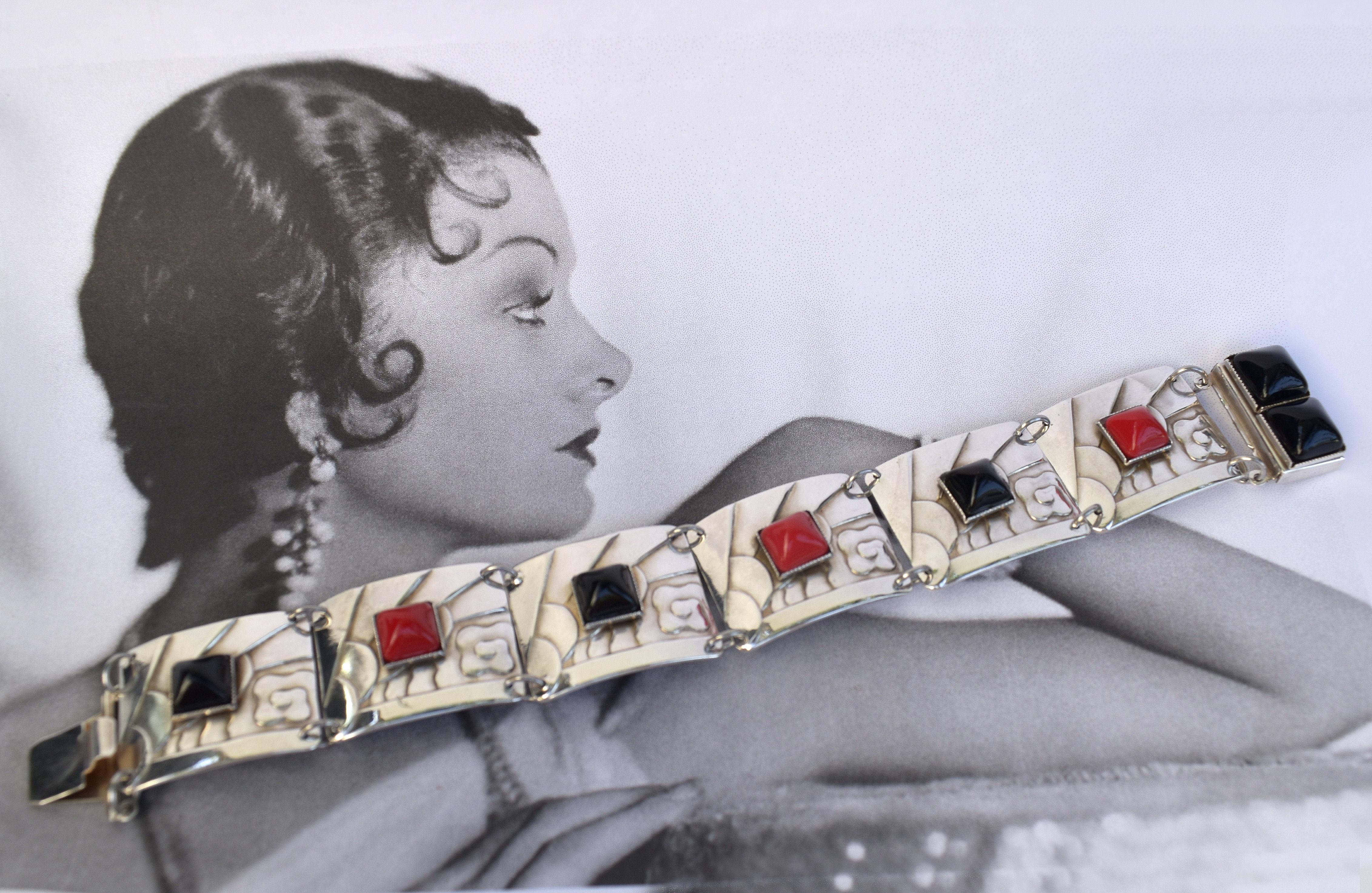 A real Art Deco classic and very high quality ladies Art Deco Modernist bracelet. Features a red and black alternate stones which are mounted on silver plated linked panels which are embossed with geometric lines, clouds etc... it just screams Art