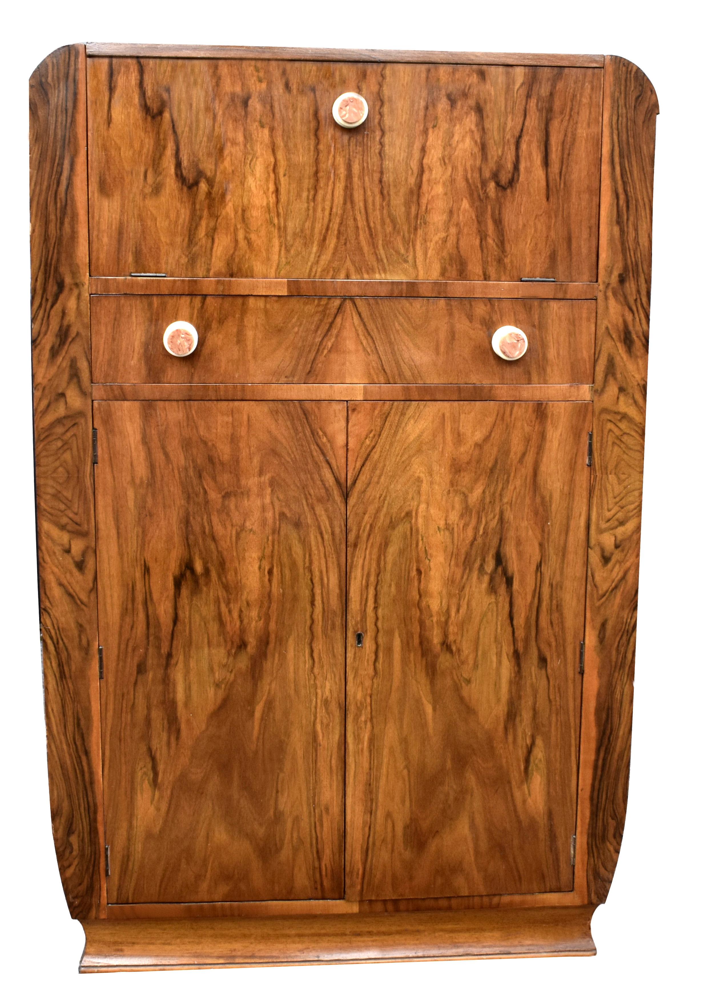 Beautiful 1930's Art Deco walnut upright cocktail cabinet, every Deco interior should have one of these ! Features a drop down top which reveals a mirrored interior and storage for glasses. A generously sized cupboard below offers plenty of storage