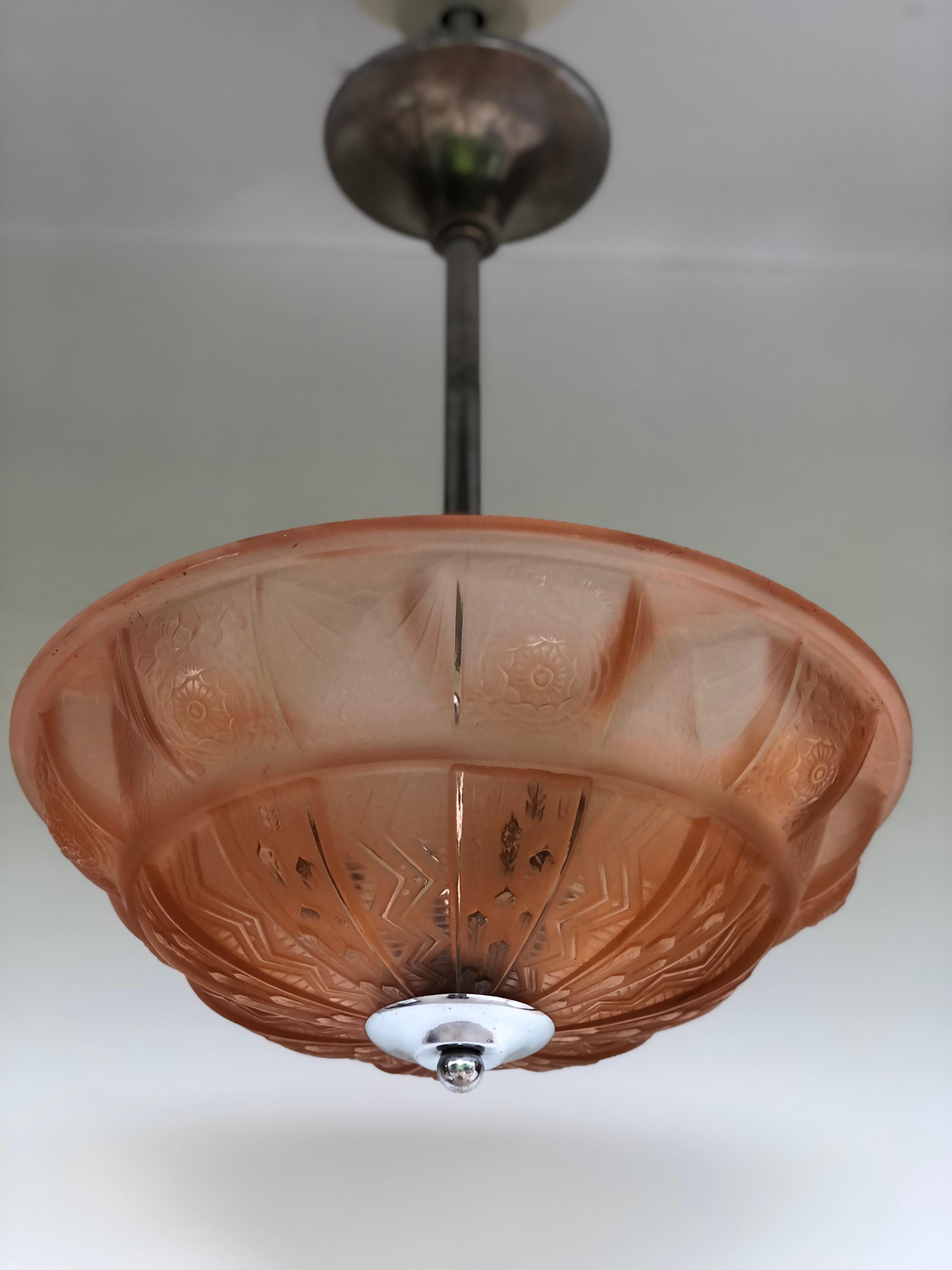 Art deco lamp circa 1930 in molded glass with geometric decoration. 
Patinated in red bun. 
In perfect condition, molded Muller Frères Luneville signature. 
Chrome-plated brass frame. 
3 Lights and electrified.
Height : 52 cm
Diameter : 40 cm