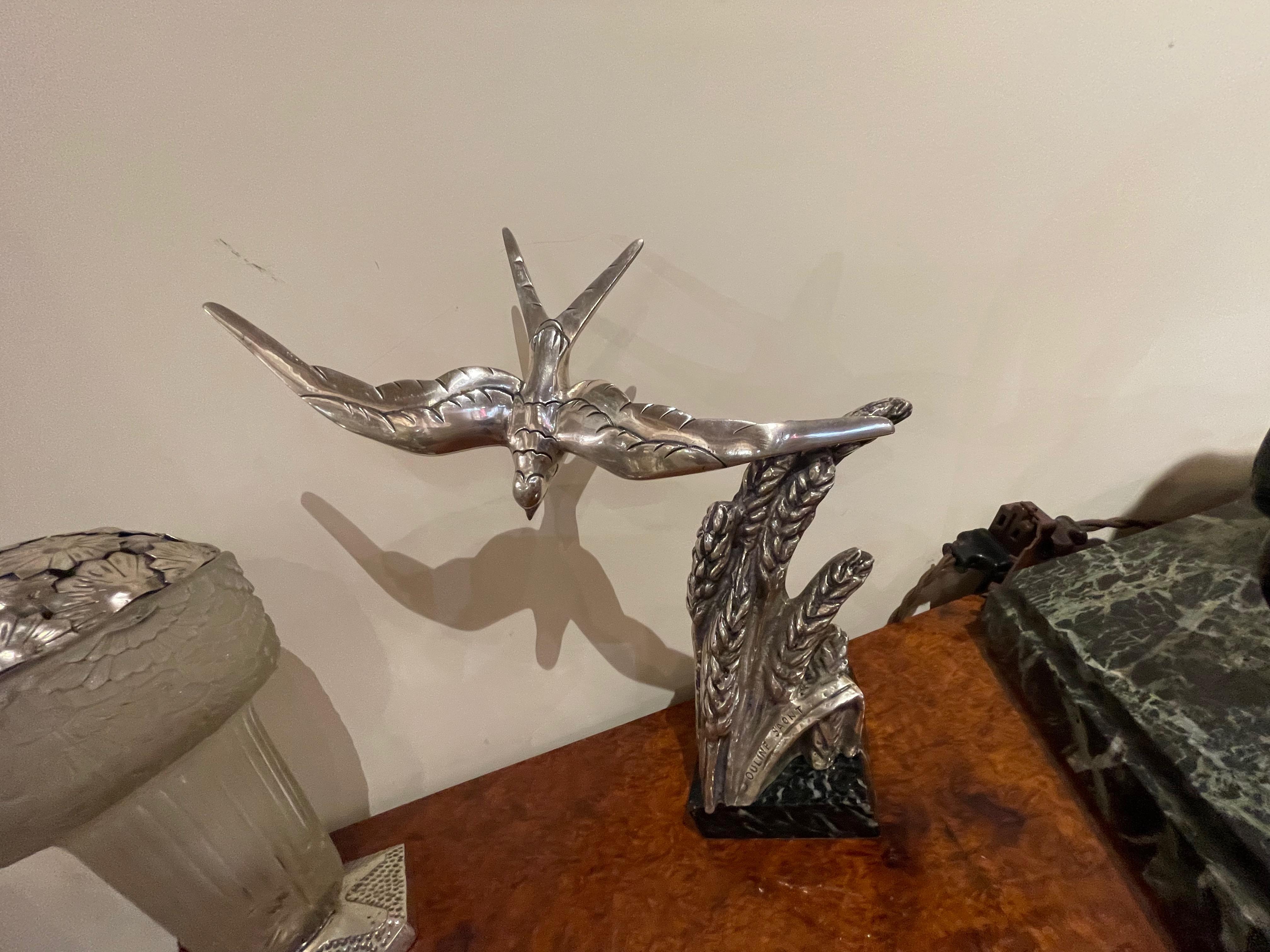 Art Deco Swallow bronze sculpture Signed Ouline. Stylized Art Deco wings showing the bird in flight, rendered as you might typically see the swallow in a natural way. Signed Ouline Saont on the lower part of the sculpture. Silvered bronze mounted on