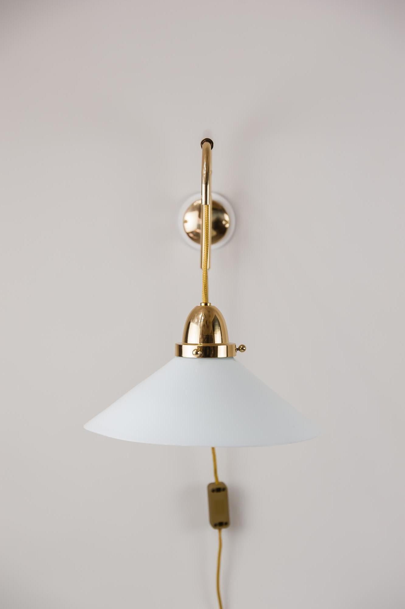 Art Deco swivelling and extendable wall lamp, circa 1920s
Brass polished and stove enamelled
Wood white painted
Normal deep 74 cm (moved out 94 cm)
Measures: High from 24 cm up to 64 cm
Original shade.
   