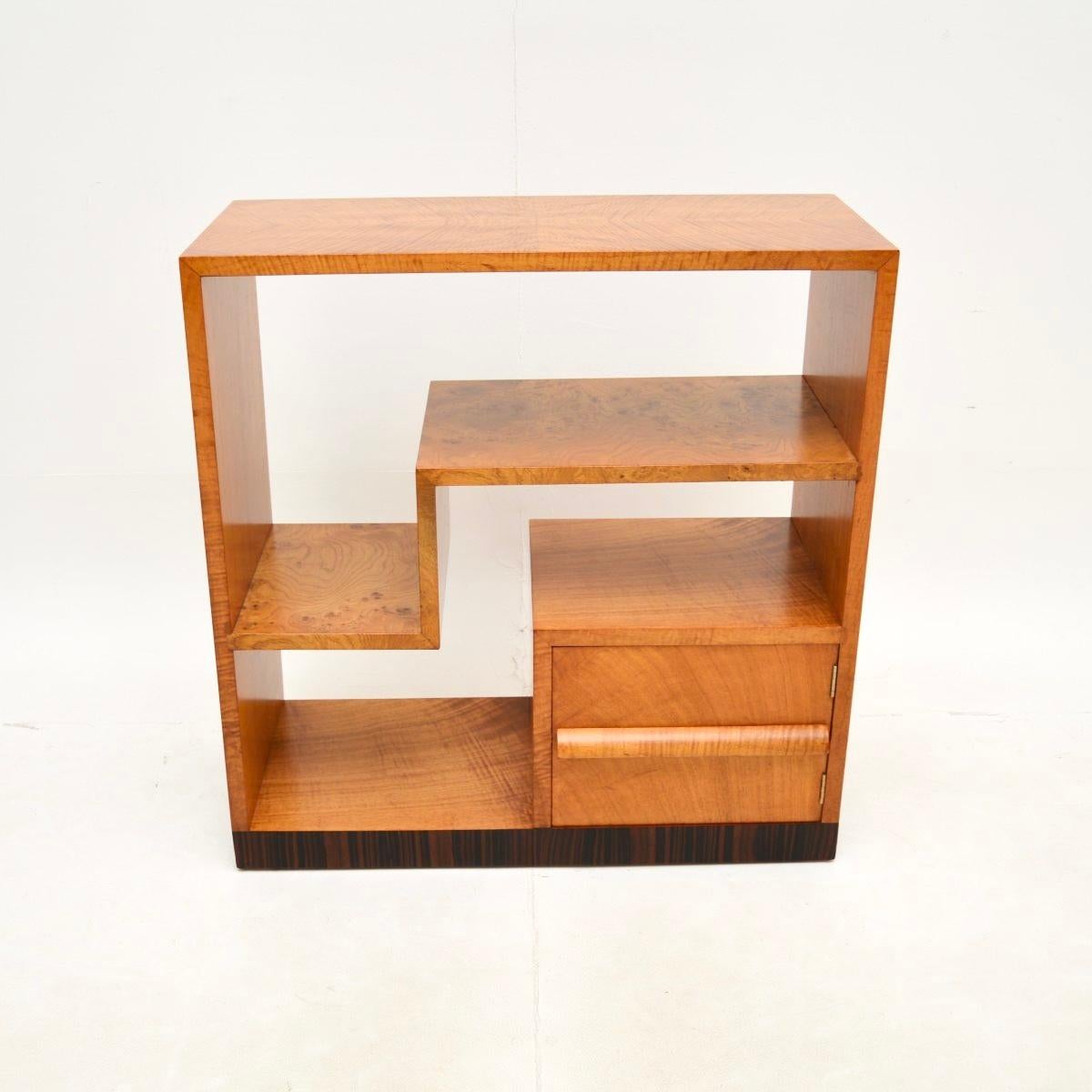 A beautiful and very striking Art Deco sycamore and elm bookcase / cabinet. This was made in England, it dates from the 1930’s.

It is of superb quality, with a very useful design. It is slim and low, perfect for use as a side / console table, with