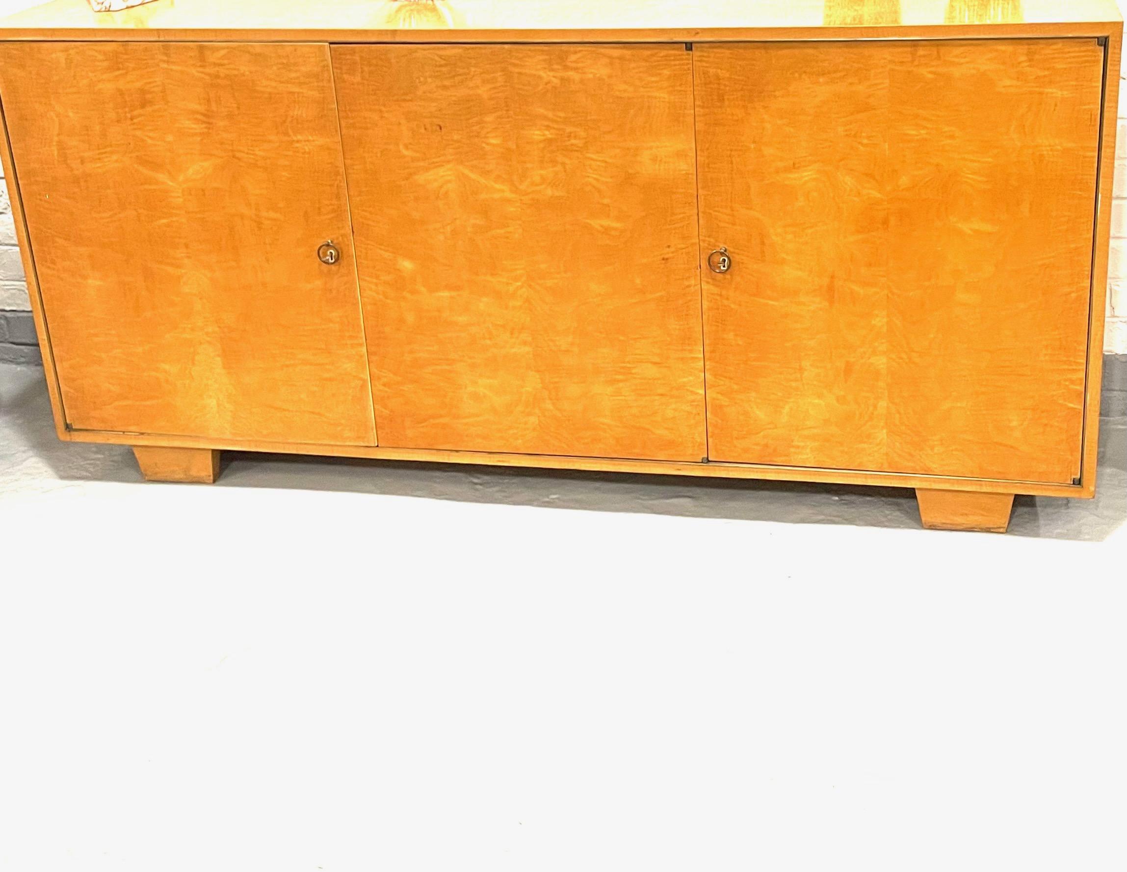 Elegant art deco sycomore three doors sideboard with multiple different size drawers in the style of Jean-Michel Frank.
Monolitic shape, brass rings handles ,bone keyholes, two keys.
Attributed to De  Coene-Frères Belgium.
Circa 1935.